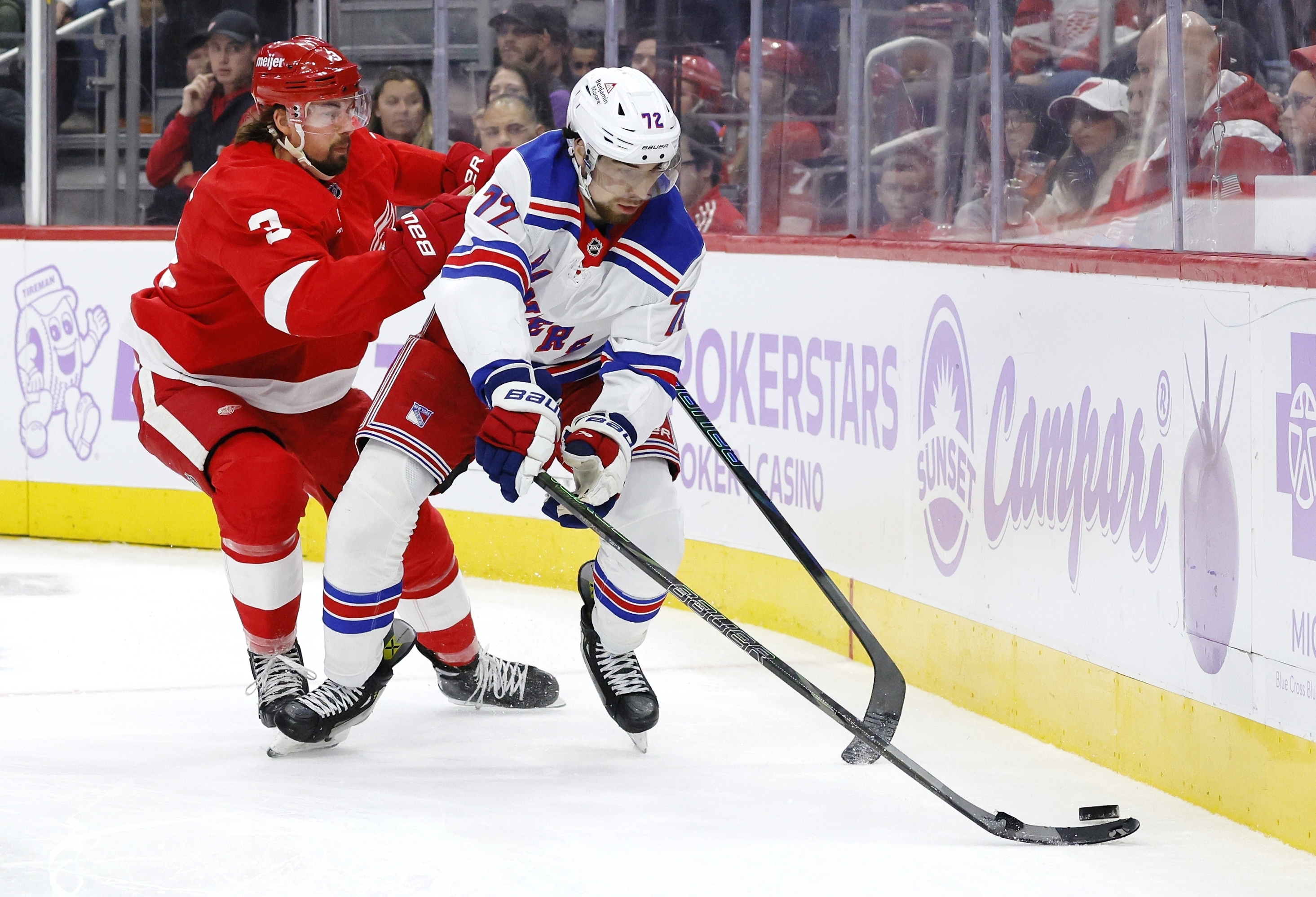 Detroit Red Wings defenseman Justin Holl (3) pursues New York Rangers center Filip Chytil (72) behind the net during the second period of an NHL hockey game Saturday, Nov. 9, 2024, in Detroit. 