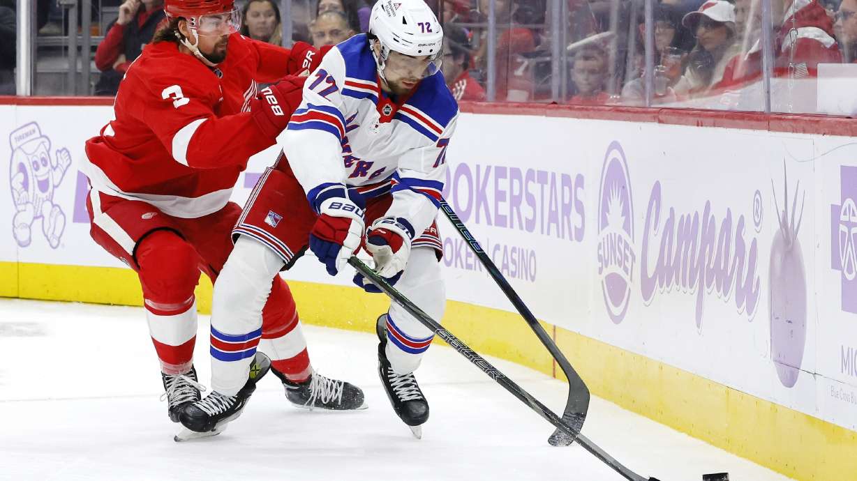 Detroit Red Wings defenseman Justin Holl (3) pursues New York Rangers center Filip Chytil (72) behind the net during the second period of an NHL hockey game Saturday, Nov. 9, 2024, in Detroit.
