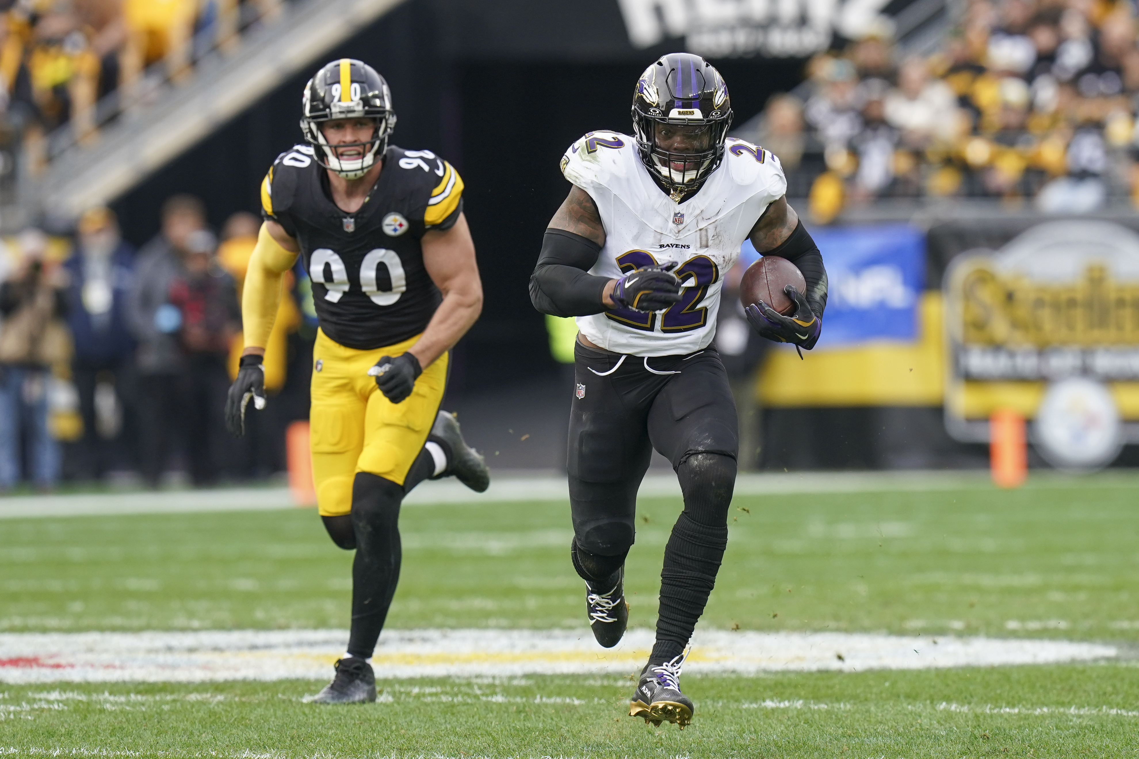 Baltimore Ravens running back Derrick Henry (22) runs with the ball in front of Pittsburgh Steelers linebacker T.J. Watt (90) during the first half of an NFL football game, Sunday, Nov. 17, 2024, in Pittsburgh. 