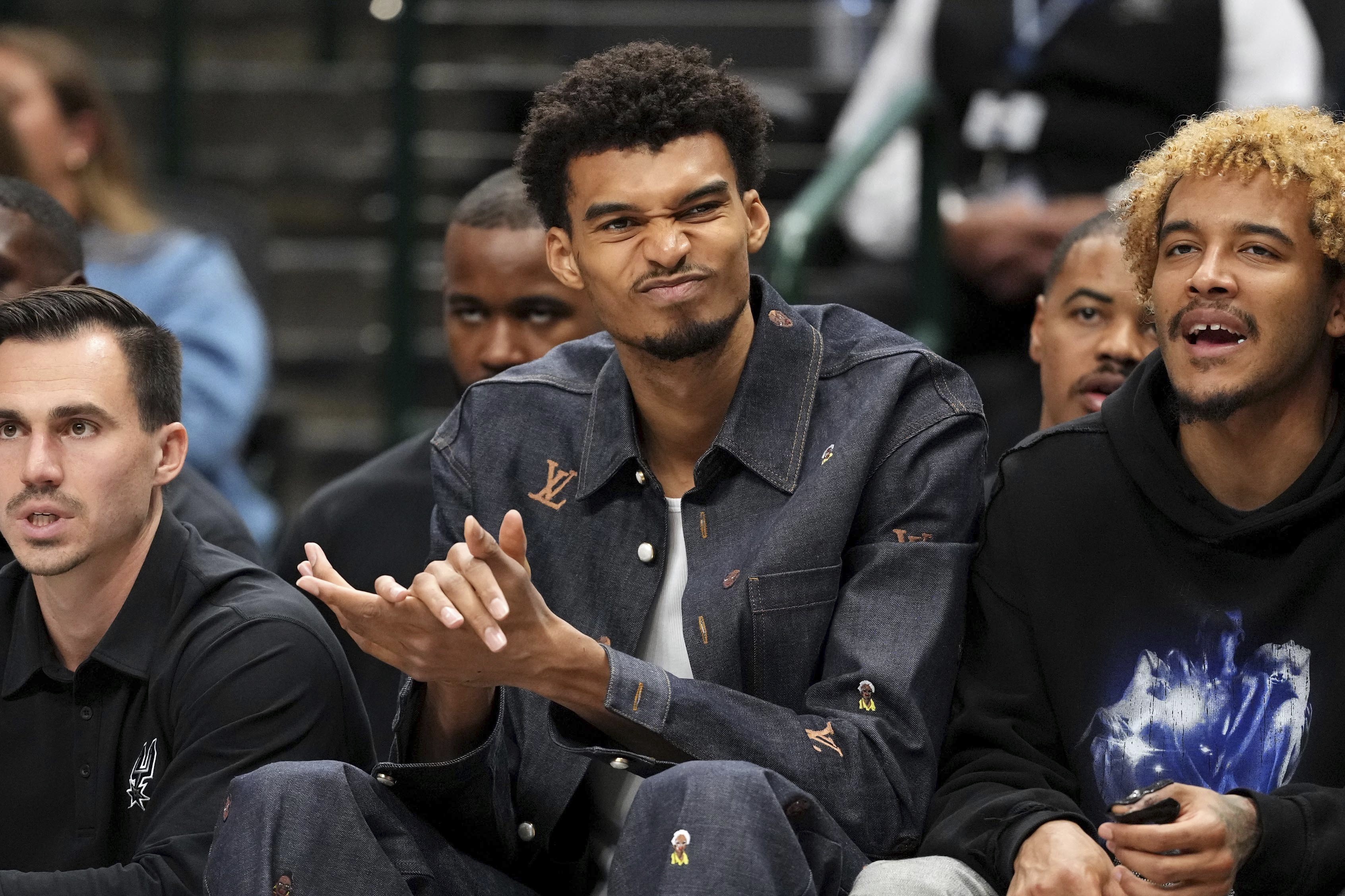 San Antonio Spurs center Victor Wembanyama, who is out with a knee contusion, reacts to a play during the second half of an NBA basketball game Saturday, Nov. 16, 2024, in Dallas. Dallas won 110-93. 