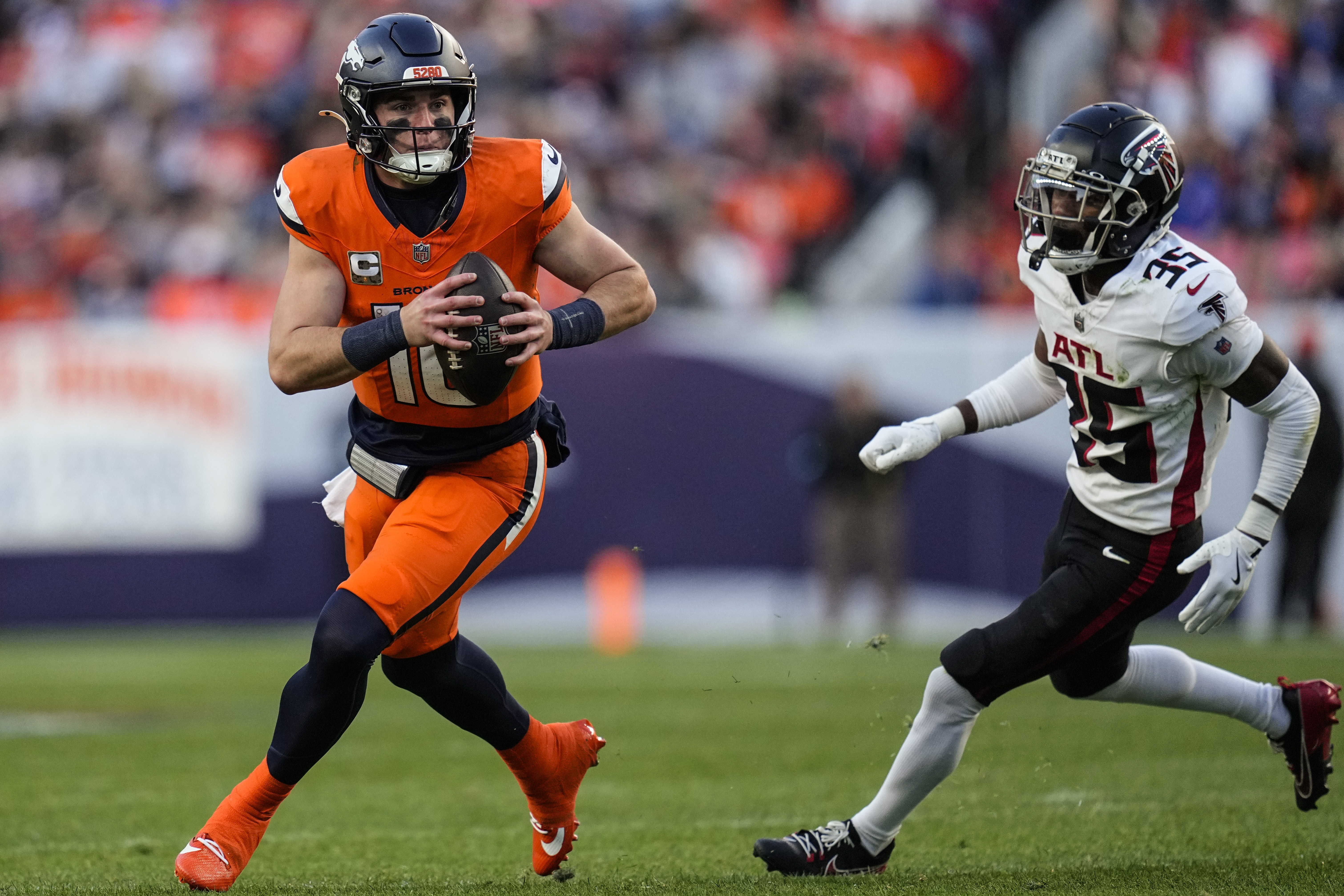 Denver Broncos quarterback Bo Nix (10) runs as Atlanta Falcons cornerback Natrone Brooks (35) pursues during the second half of an NFL football game, Sunday, Nov. 17, 2024, in Denver. 