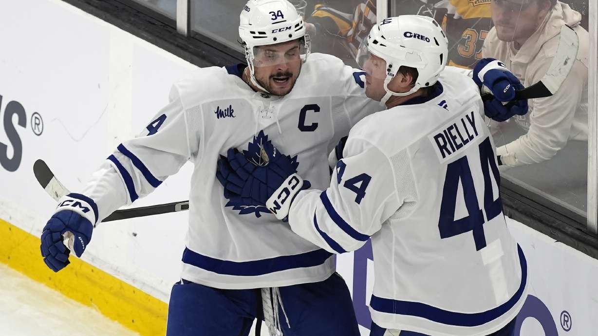 Toronto Maple Leafs' Morgan Rielly (44) celebrates his goal with Auston Matthews (34) during the second period of an NHL hockey game against the Boston Bruins, Saturday, Oct. 26, 2024, in Boston.