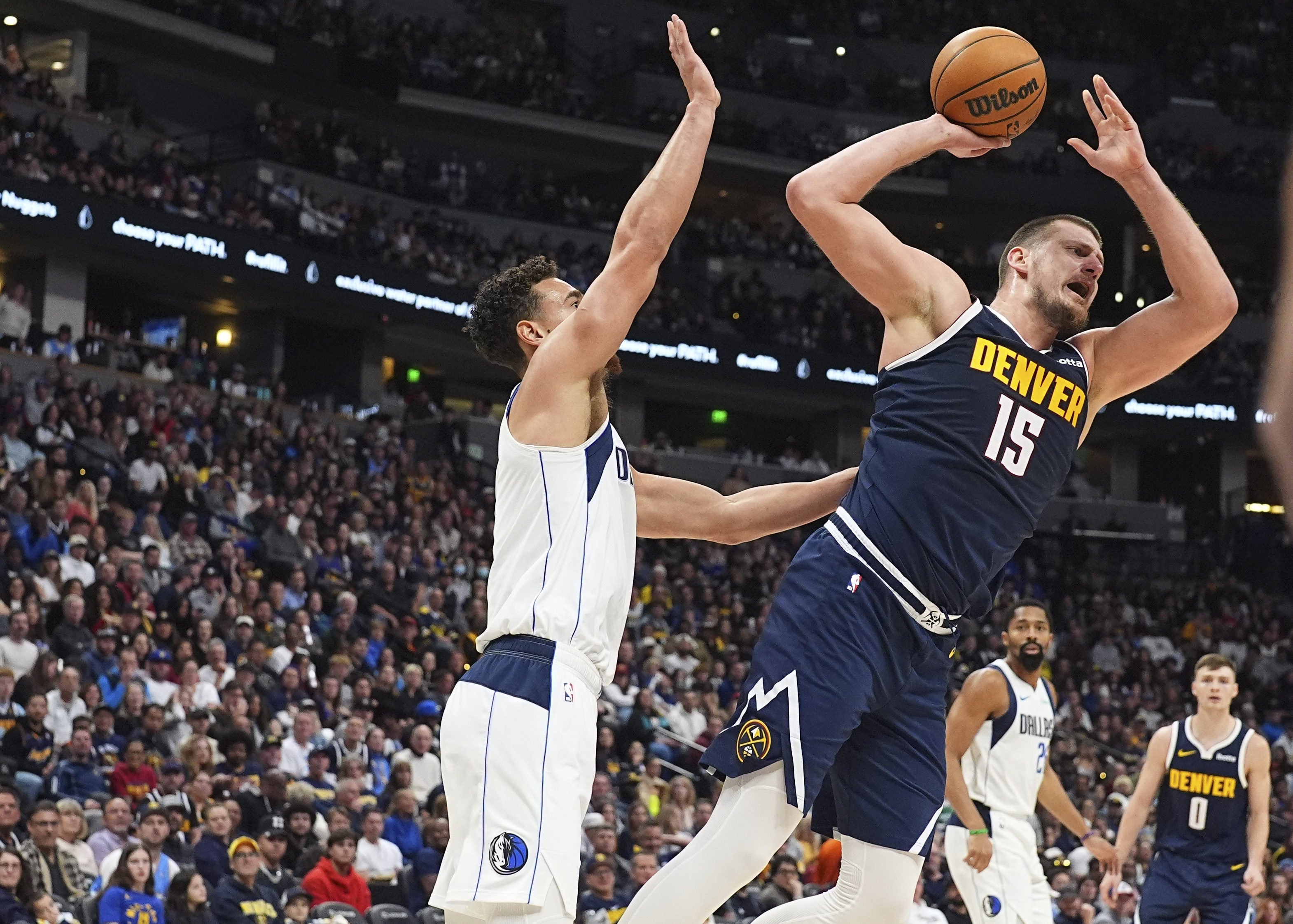 Denver Nuggets center Nikola Jokic, right, is fouled by Dallas Mavericks center Dwight Powell as he goes up for a shot in the second half of an NBA basketball game Sunday, Nov. 10, 2024, in Denver. 