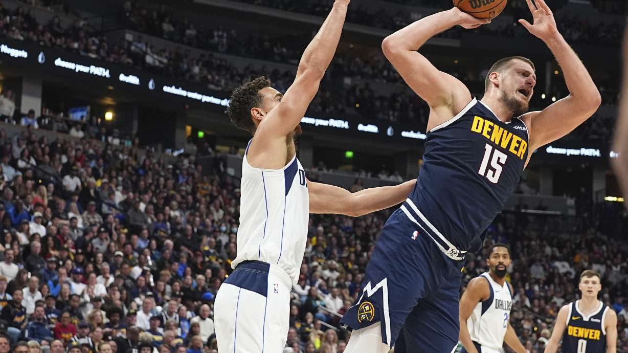 Denver Nuggets center Nikola Jokic, right, is fouled by Dallas Mavericks center Dwight Powell as he goes up for a shot in the second half of an NBA basketball game Sunday, Nov. 10, 2024, in Denver.