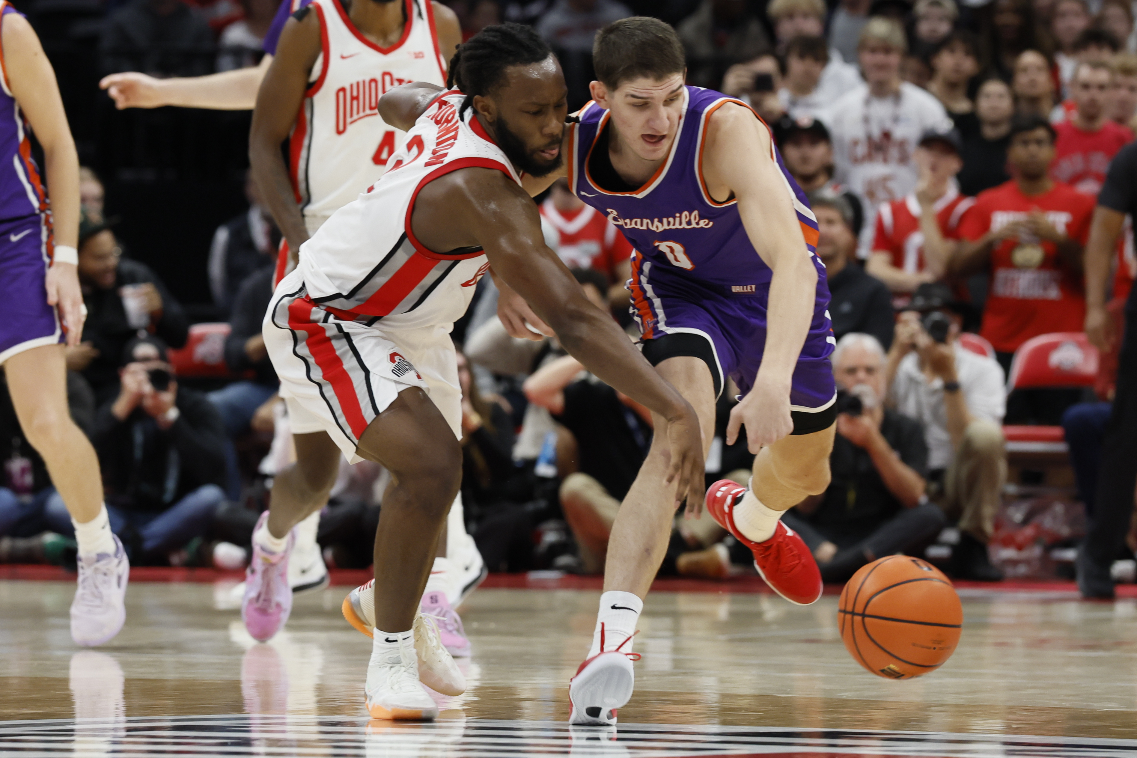 Ohio State's Bruce Thornton, left, and Evansville's Gabriel Pozzato chase the ball during the first half of an NCAA college basketball game Tuesday, Nov. 19, 2024, in Columbus, Ohio.