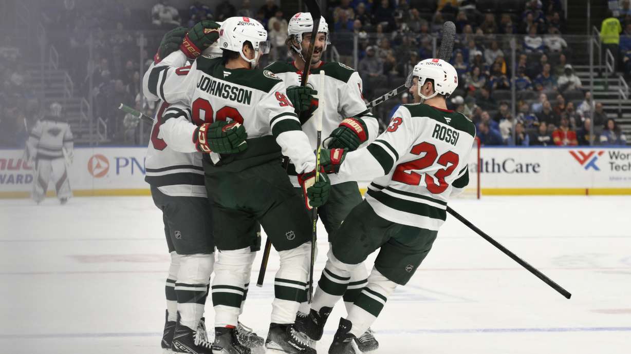 Minnesota Wild center Marco Rossi (23) celebrates with teammates after a goal scored by right wing Ryan Hartman, far left, against the St. Louis Blues during the first period of an NHL hockey game Tuesday, Nov. 19, 2024, in St. Louis.