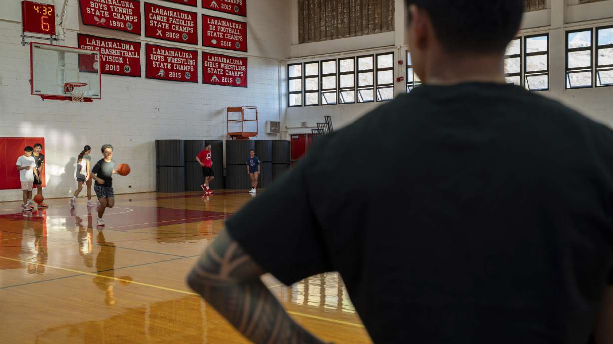 TJ Rickard, Lahainaluna High School boys basketball coach, watches his players warm up at Lahainaluna High School, Monday, Nov. 18, 2024, in Lahaina, Hawaii.