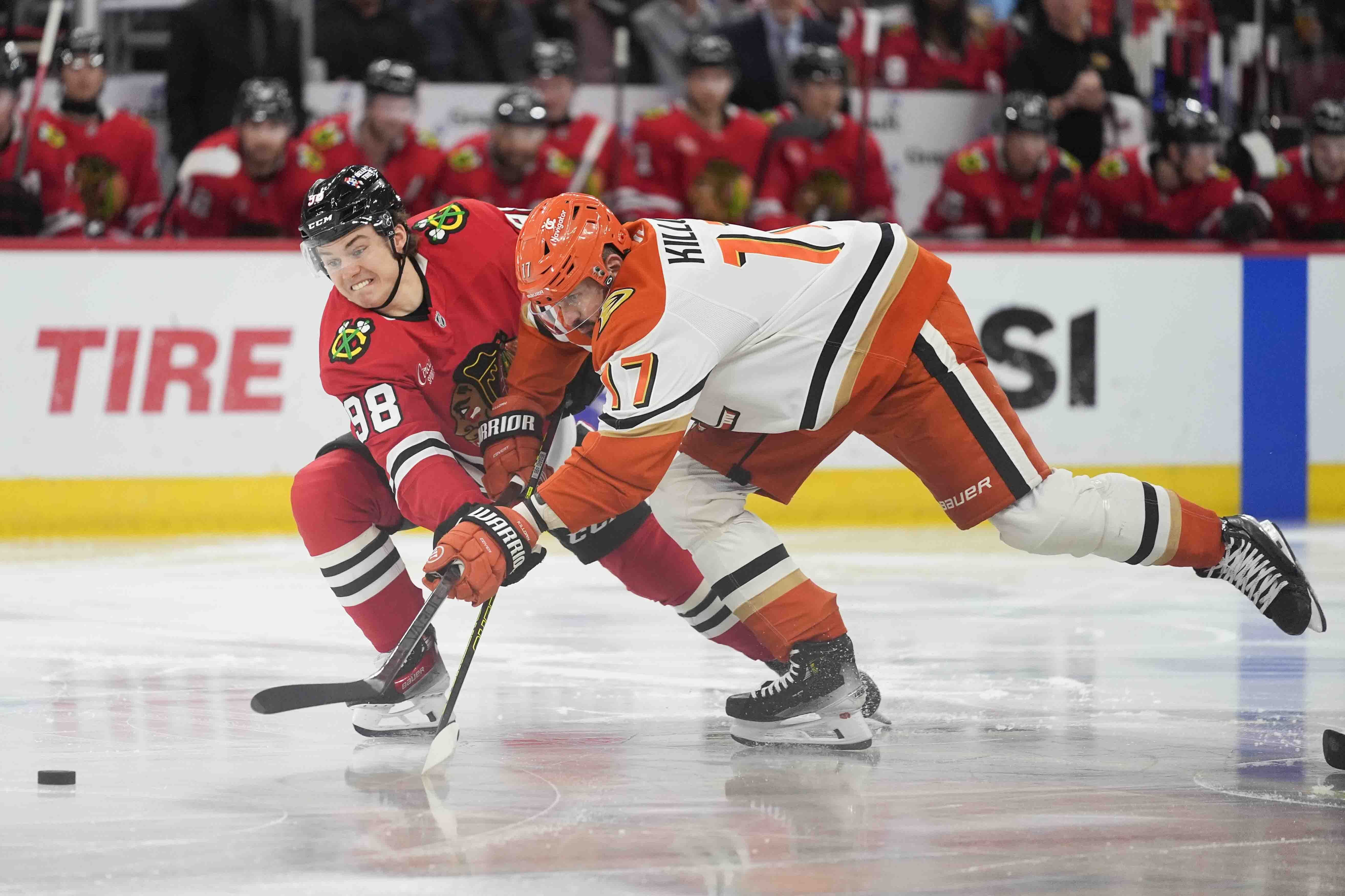 Chicago Blackhawks center Connor Bedard, left, and Anaheim Ducks left wing Alex Killorn fight for control of the puck during the second period of an NHL hockey game Tuesday, Nov. 19, 2024, in Chicago.