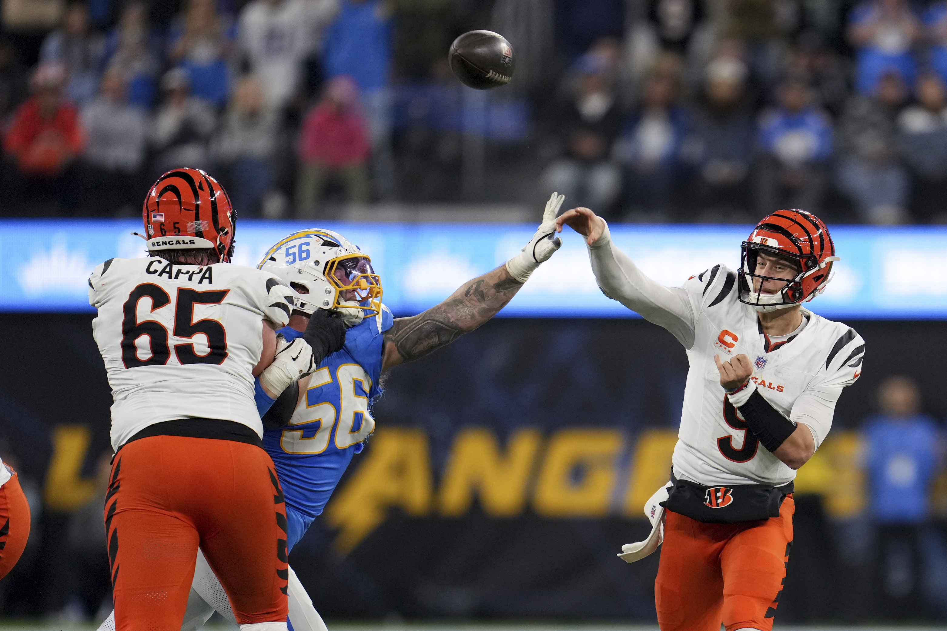 Cincinnati Bengals quarterback Joe Burrow (9) throws a pass under pressure from Los Angeles Chargers defensive end Morgan Fox (56) during the second half of an NFL football game Sunday, Nov. 17, 2024, in Inglewood, Calif.