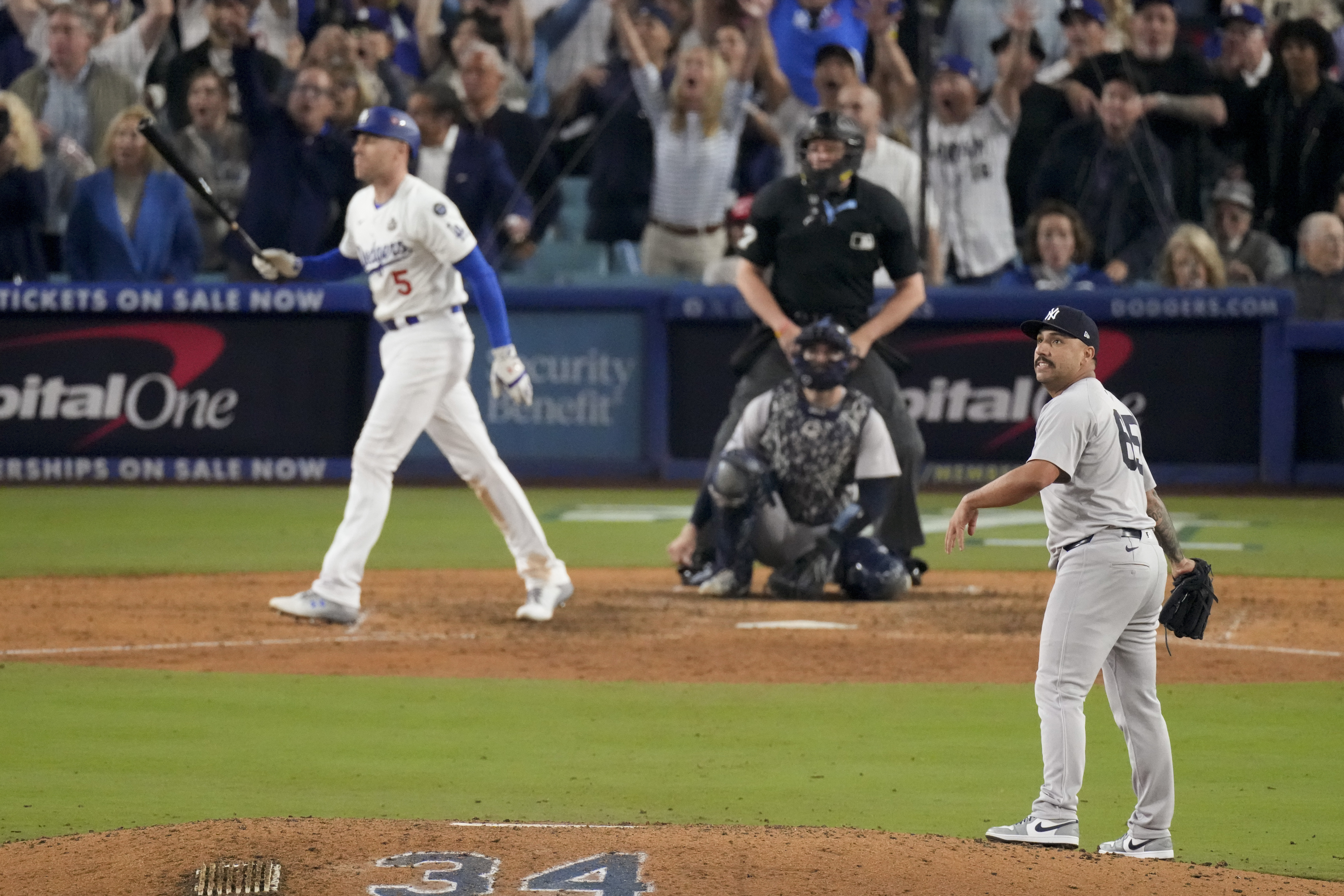 New York Yankees relief pitcher Nestor Cortes, right, watches as Los Angeles Dodgers' Freddie Freeman, left, hits a walk-off grand slam home run during the 10th inning in Game 1 of the baseball World Series against the New York Yankees, Friday, Oct. 25, 2024, in Los Angeles.