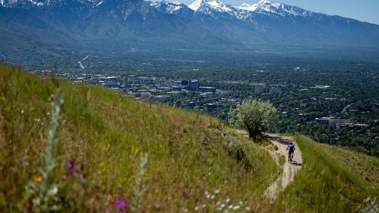 A cyclist rides on the Bonneville Shoreline Trail in the foothills above Salt Lake City on June 2, 2022. Several trails in in the area remain closed as Rocky Mountain Power carries out a wildfire mitigation project