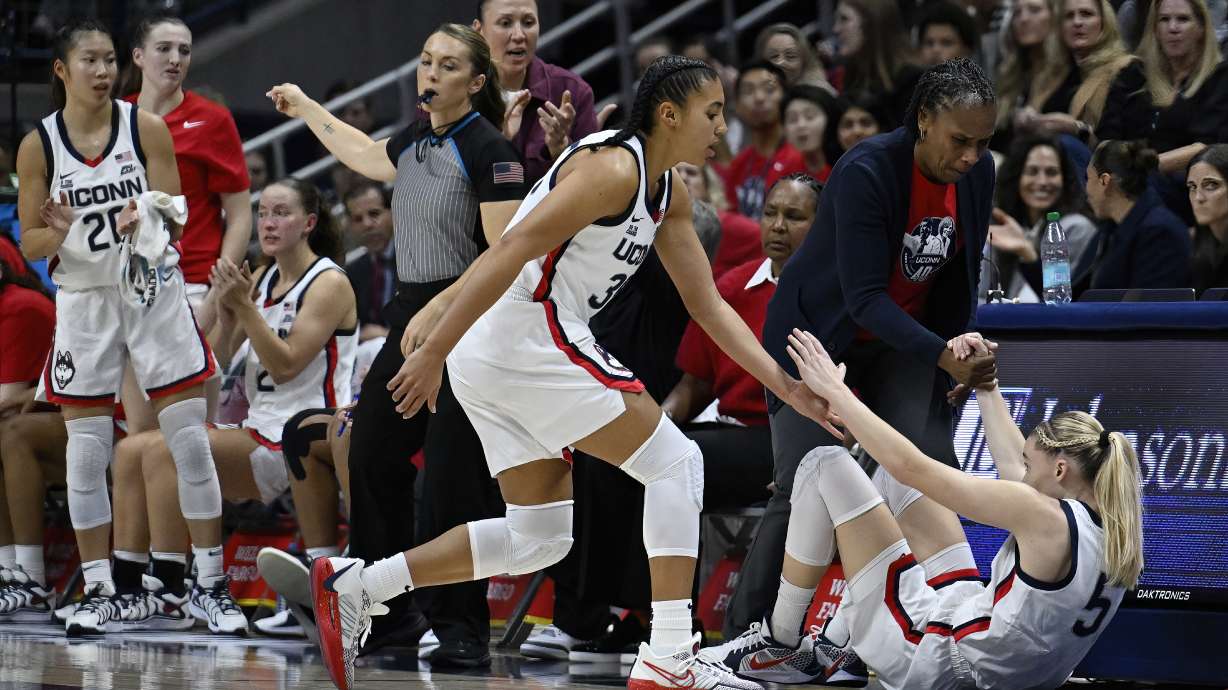UConn guard Azzi Fudd, left and assistant coach Jamelle Elliott, right, help UConn guard Paige Bueckers up off the floor in the first half of an NCAA college basketball game against Fairleigh Dickinson, Wednesday, Nov. 20, 2024, in Storrs, Conn.