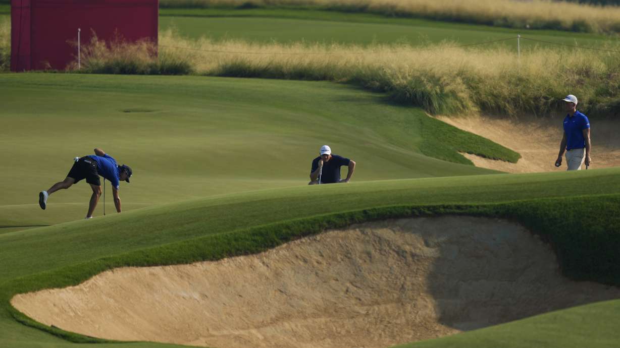Min Woo Lee of Australia, left, Justin Rose of England, centre, and Nicolai Hojgaard of Denmark prepare to plays their second shot at the 3rd hole during the second round of Abu Dhabi Golf Championship in Abu Dhabi, United Arab Emirates, Friday, Nov. 8, 2024.