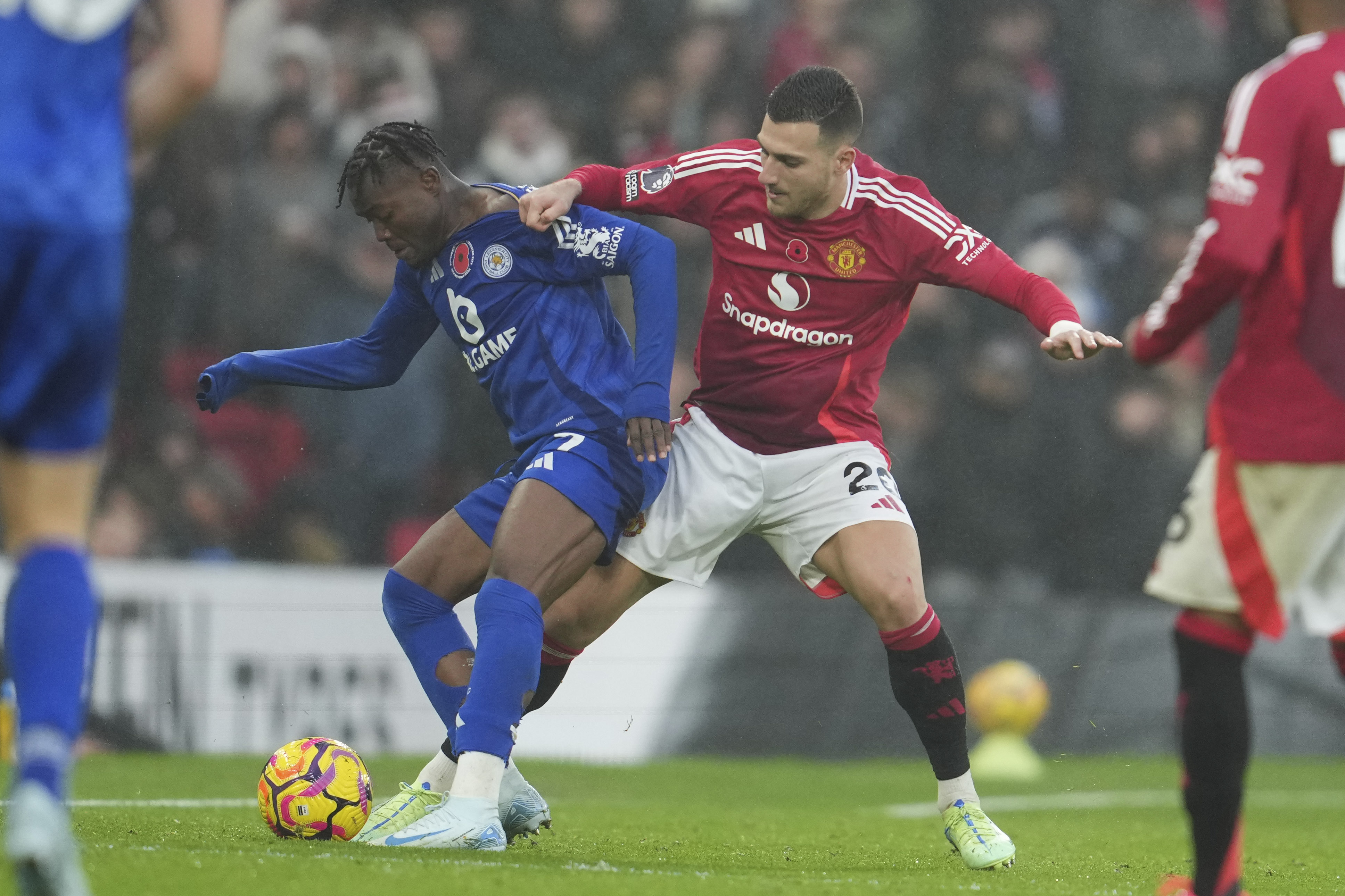 Manchester United's Diogo Dalot challenges for the ball with Leicester's Abdul Fatawu during the English Premier League soccer match between Manchester United and Leicester City, at the Old Trafford stadium in Manchester, England, Sunday, Nov.10, 2024.