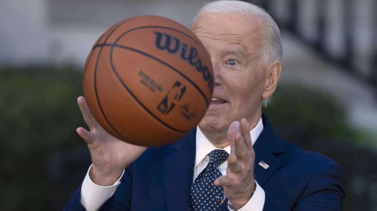 President Joe Biden throws a basketball he received from the Boston Celtics at an event to celebrate the team's victory in the 2024 National Basketball Association Championship, on the South Lawn of the White House in Washington, Thursday, Nov. 21, 2024.