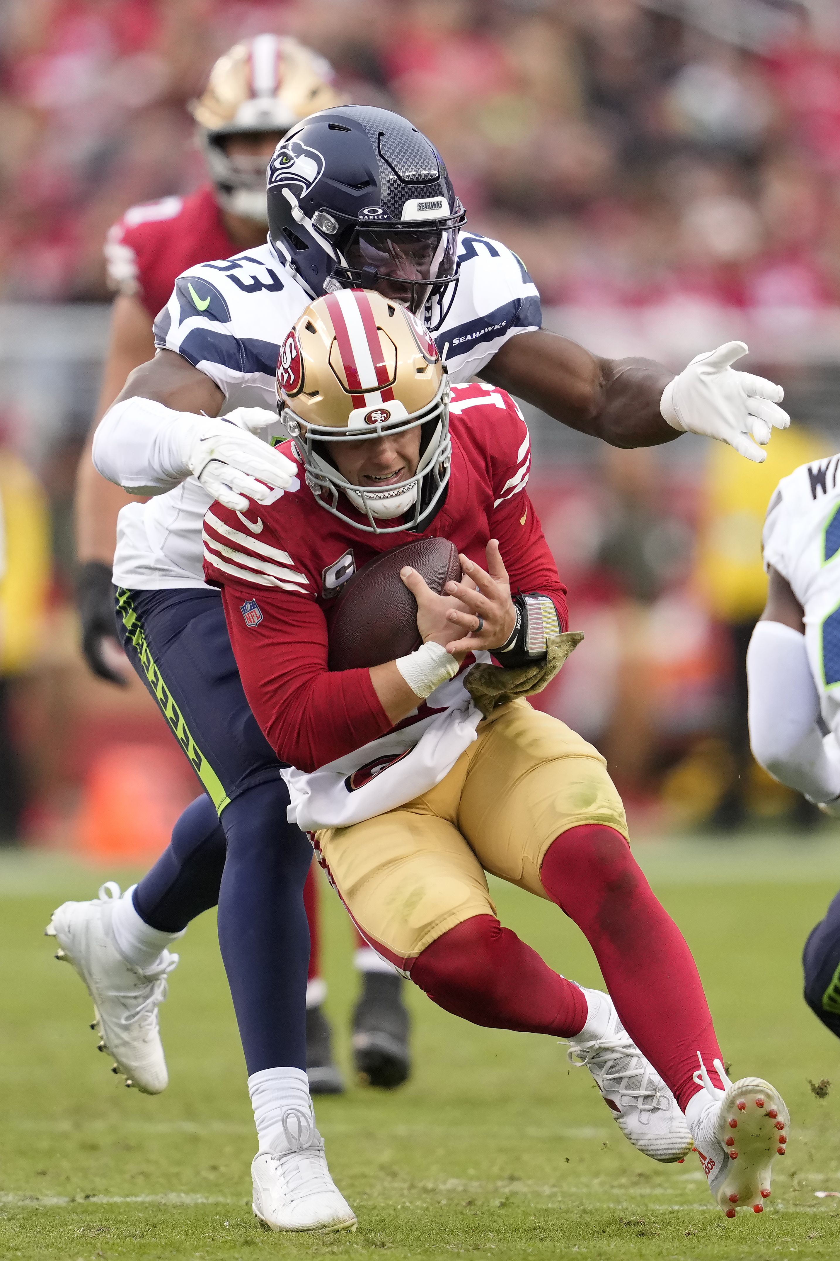 San Francisco 49ers quarterback Brock Purdy, bottom, runs against Seattle Seahawks linebacker Boye Mafe (53) during the second half of an NFL football game in Santa Clara, Calif., Sunday, Nov. 17, 2024.