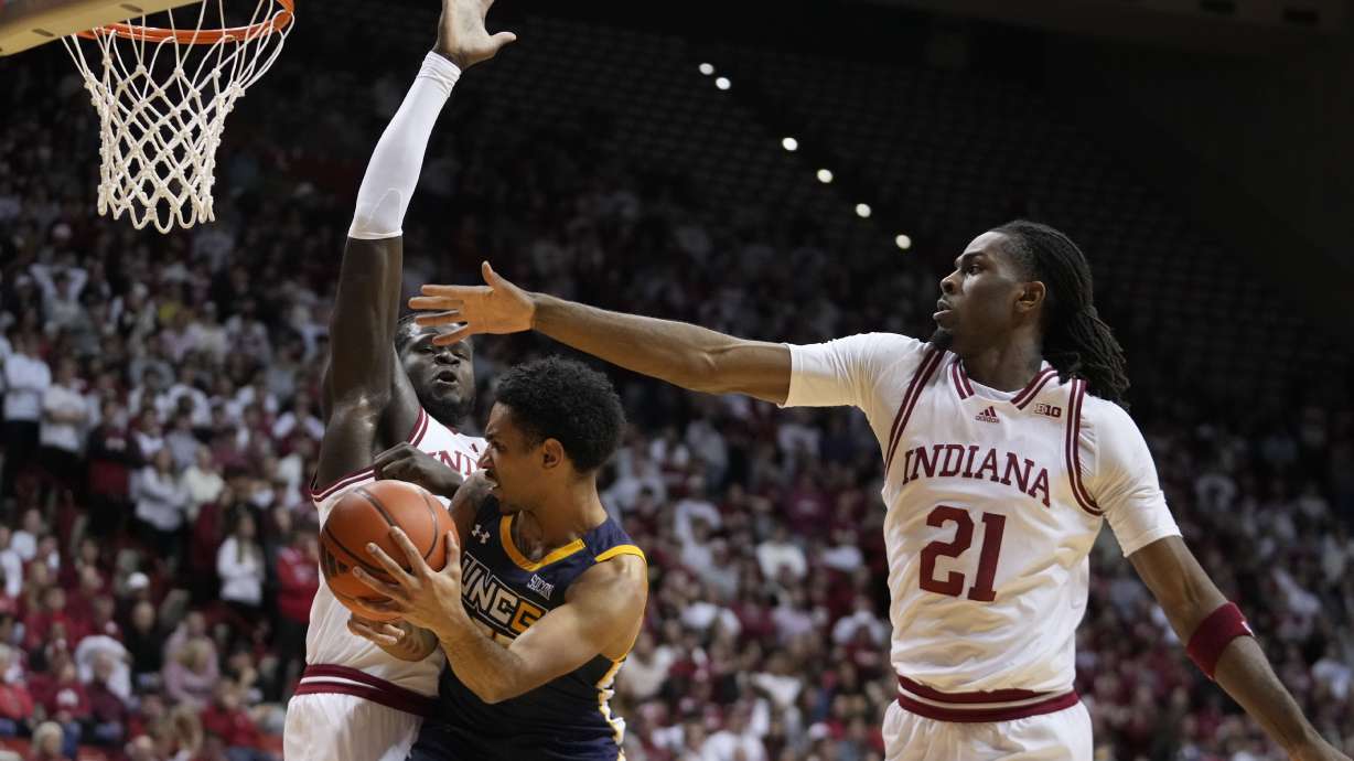 UNC Greensboro's Joryam Saizonou makes a pass against Indiana's Oumar Ballo, left, and Mackenzie Mgbako (21) during the first half of an NCAA college basketball game, Thursday, Nov. 21, 2024, in Bloomington, Ind.