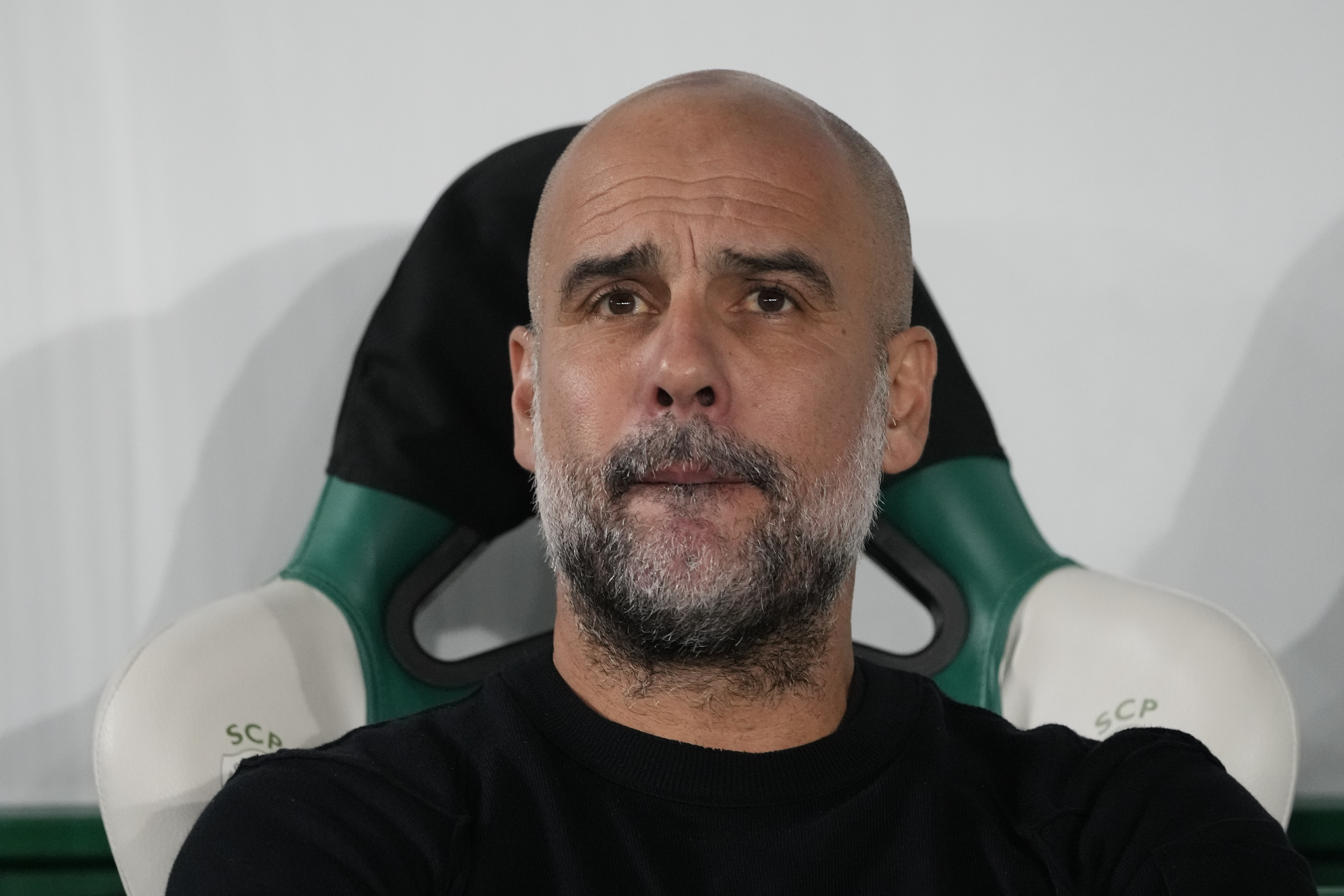 Manchester City's head coach Pep Guardiola sits before the UEFA Champions League opening phase match between Sporting and Manchester City in Lisbon, Portugal, Tuesday, Nov. 5, 2024.
