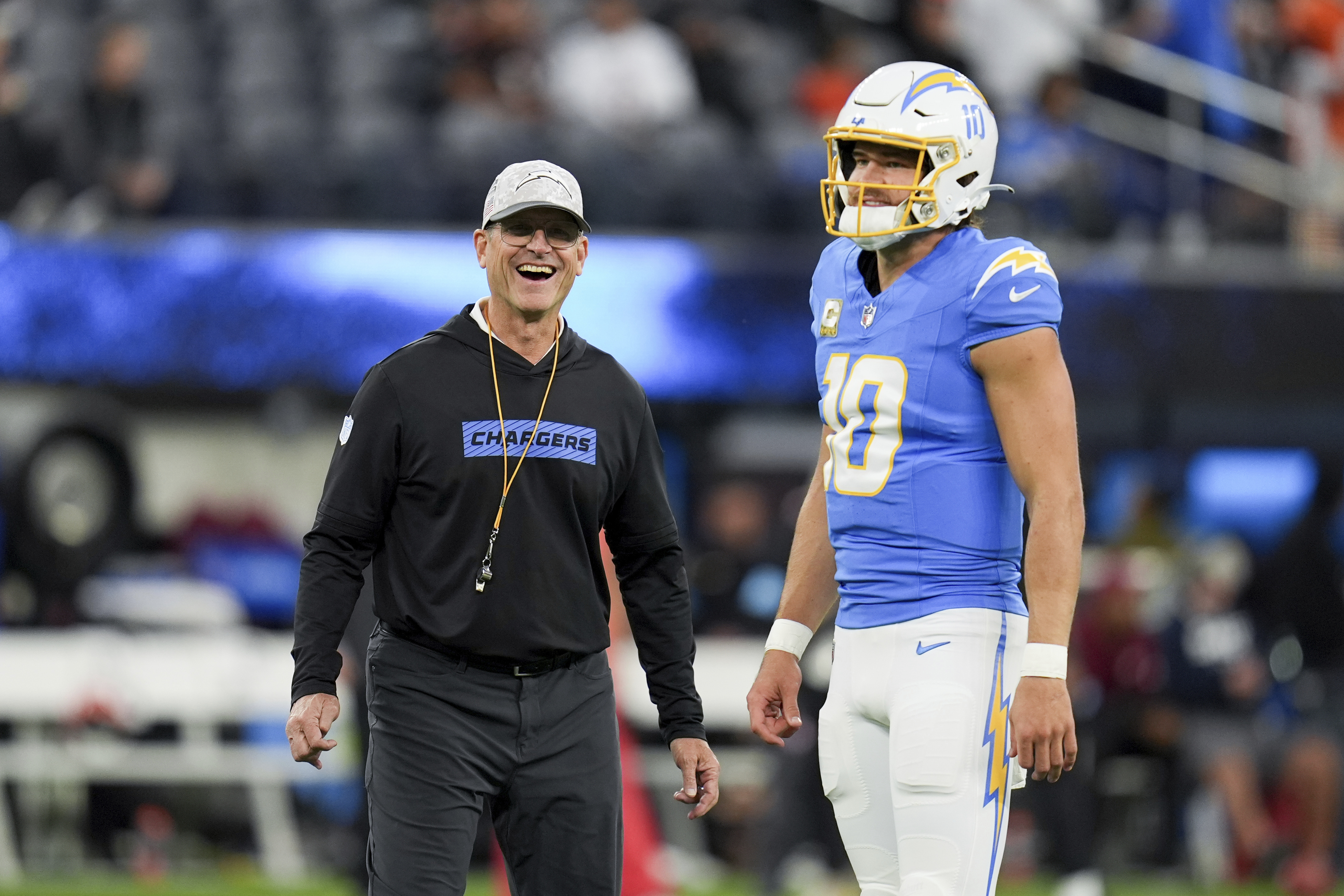 Los Angeles Chargers head coach Jim Harbaugh smiles next to quarterback Justin Herbert (10) before an NFL football game against the Cincinnati Bengals, Sunday, Nov. 17, 2024, in Inglewood, Calif.