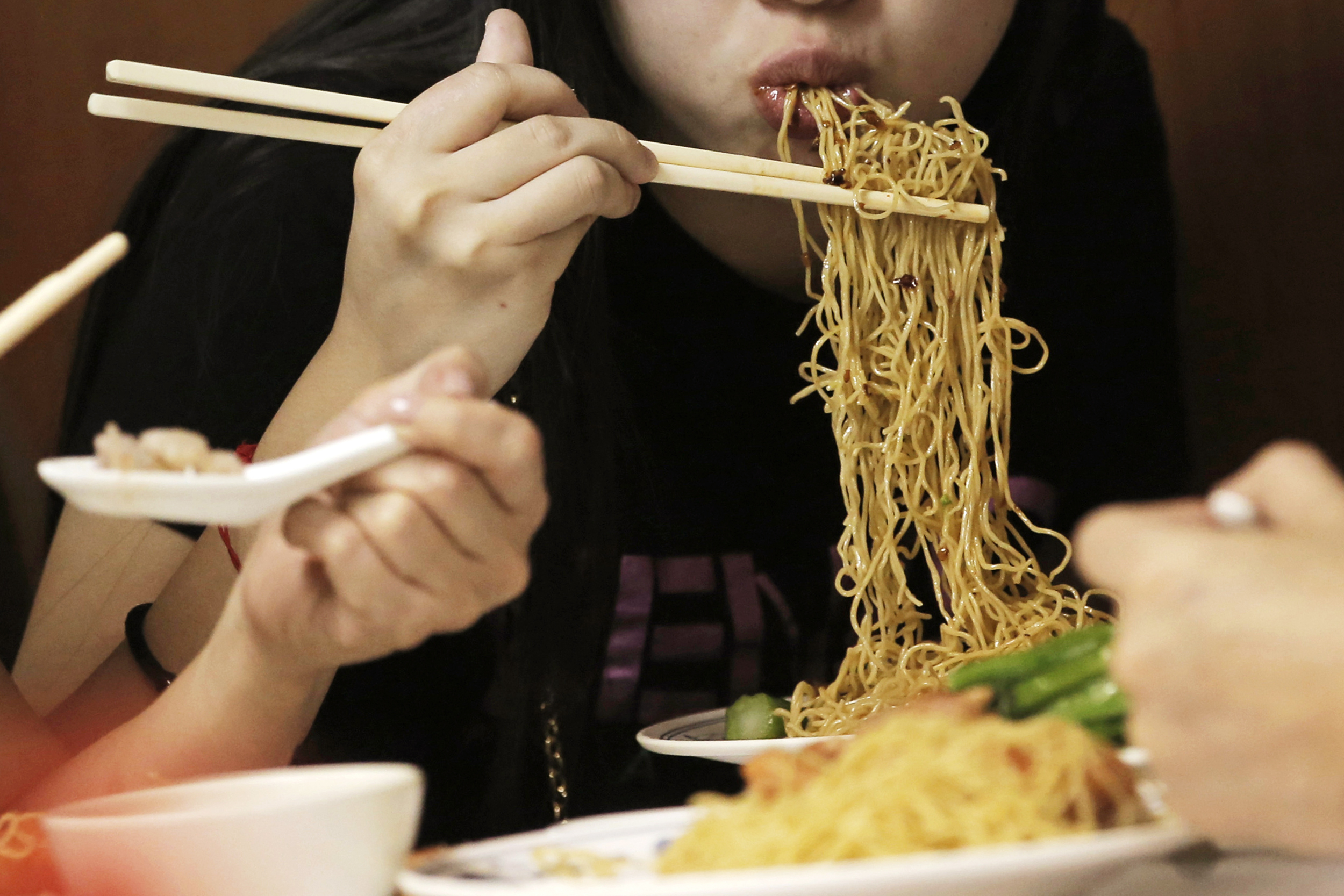 ALTERNATIVE CROP FILE - Customers eat noodles at the Wing Wah Noodle Shop in Hong Kong, on July 12, 2018.