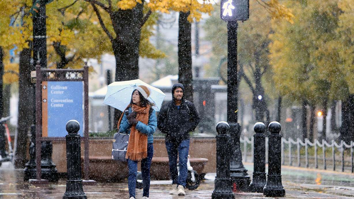 Janet Kuo walks through downtown Salt Lake City during a snowstorm on Nov. 12. A pair of storms are expected to bring more rain and snow across Utah between Saturday evening and Wednesday.