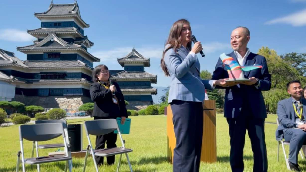 Salt Lake City Mayor Erin Mendenhall speaks as she hands over a miniature version of "Out of the Blue" to Yoshinao Gaun, mayor of Matsumoto, Japan, during a ceremony outside the Matsumoto Castle in early October.