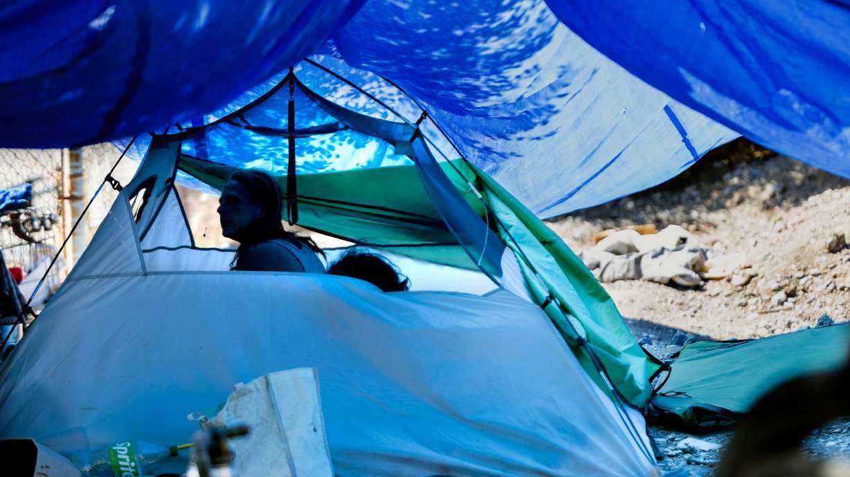 A couple sits in their tent in a camp in Salt Lake City on June 28. Two advocates for those experiencing homelessness offered contrasting views on how to help those in need.
