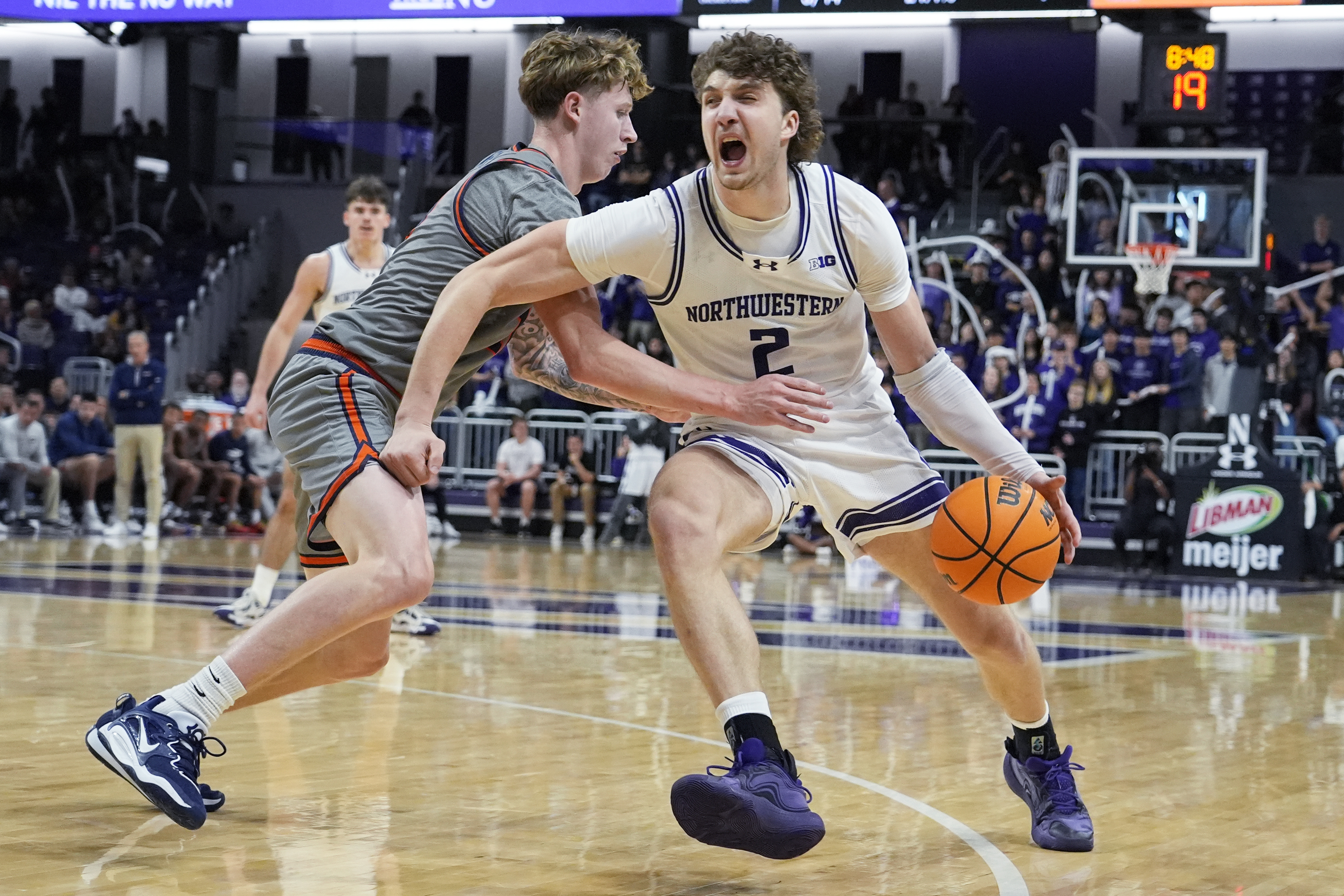 Northwestern forward Nick Martinelli, right, drives against Pepperdine guard Jaxon Olvera, left, during the second half of an NCAA college basketball game in Evanston, Ill., Friday, Nov. 22, 2024. 