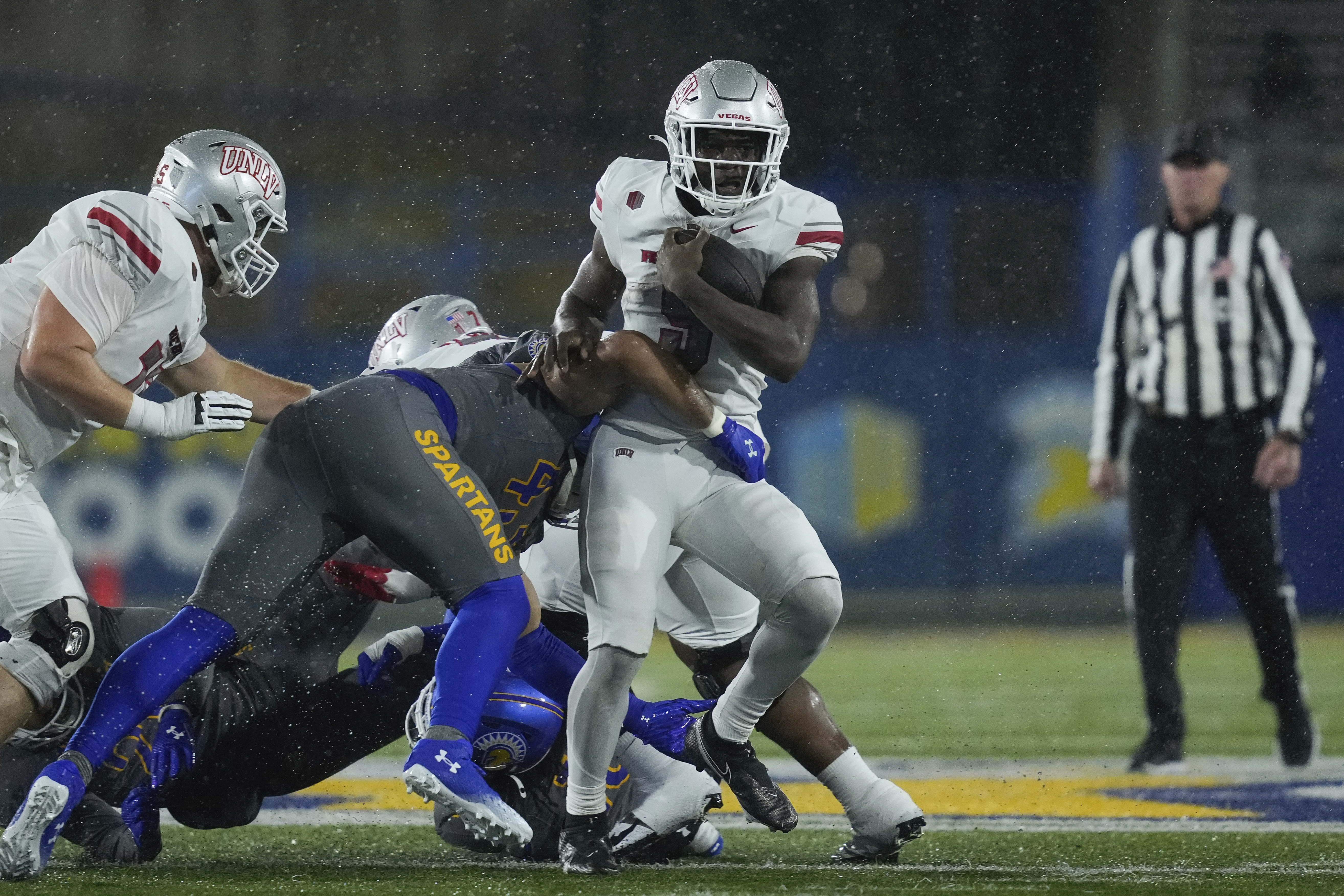 UNLV running back Jai'Den Thomas, right, is tackled by San Jose State linebacker John Ward during the first half of an NCAA college football game Friday, Nov. 22, 2024, in San Jose, Calif.