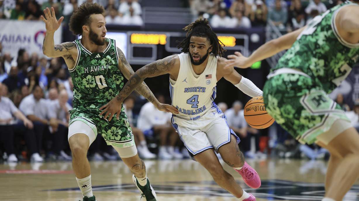 North Carolina guard RJ Davis (4) dribbles past Hawaii guard Kody Williams (0) during the second half of an NCAA college basketball game, Friday, Nov. 22, 2024, in Honolulu.