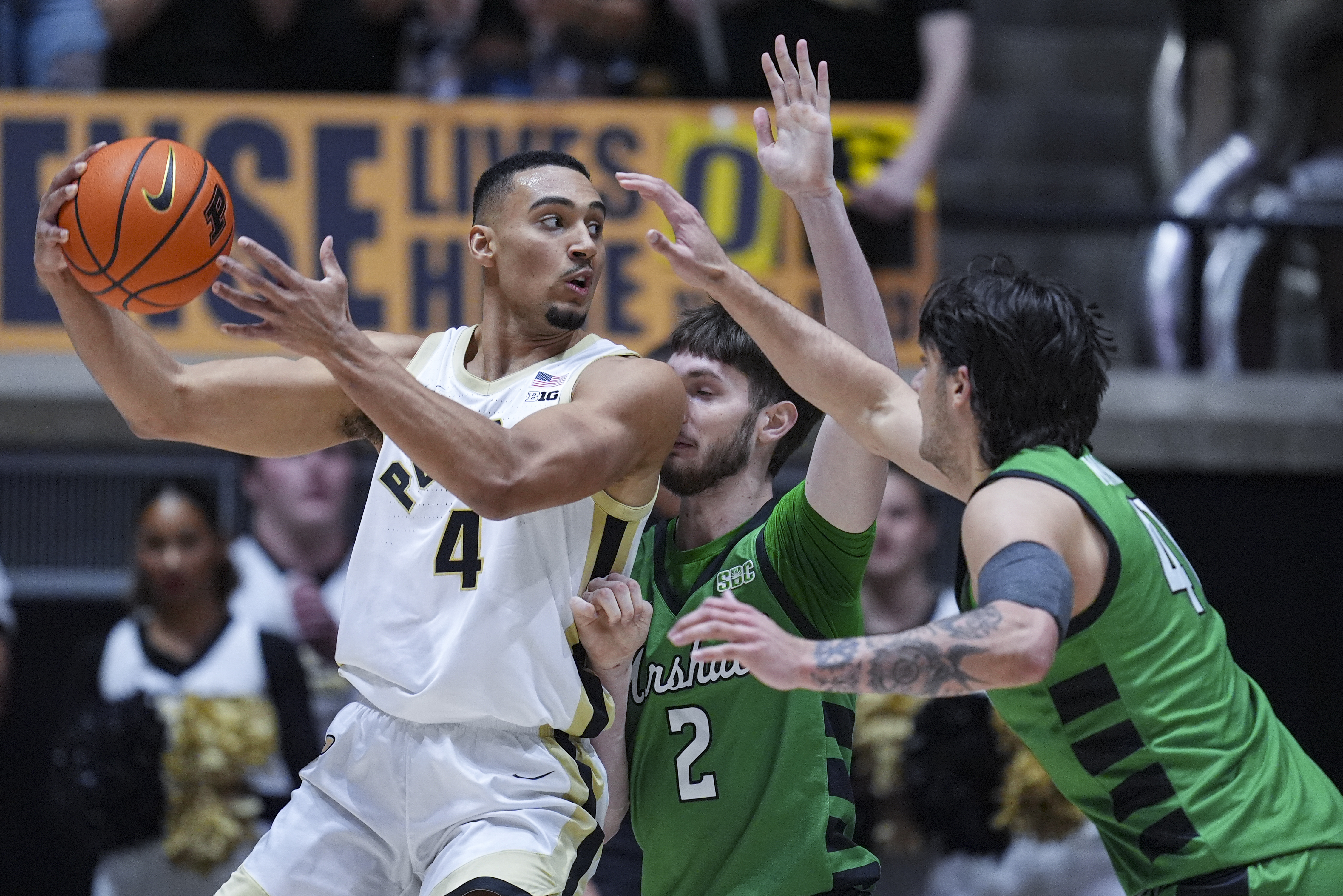 Purdue forward Trey Kaufman-Renn (4) makes a pass over Marshall forward Wyatt Fricks (2) and forward Nate Martin (41) during the first half of an NCAA college basketball game in West Lafayette, Ind., Saturday, Nov. 23, 2024. 