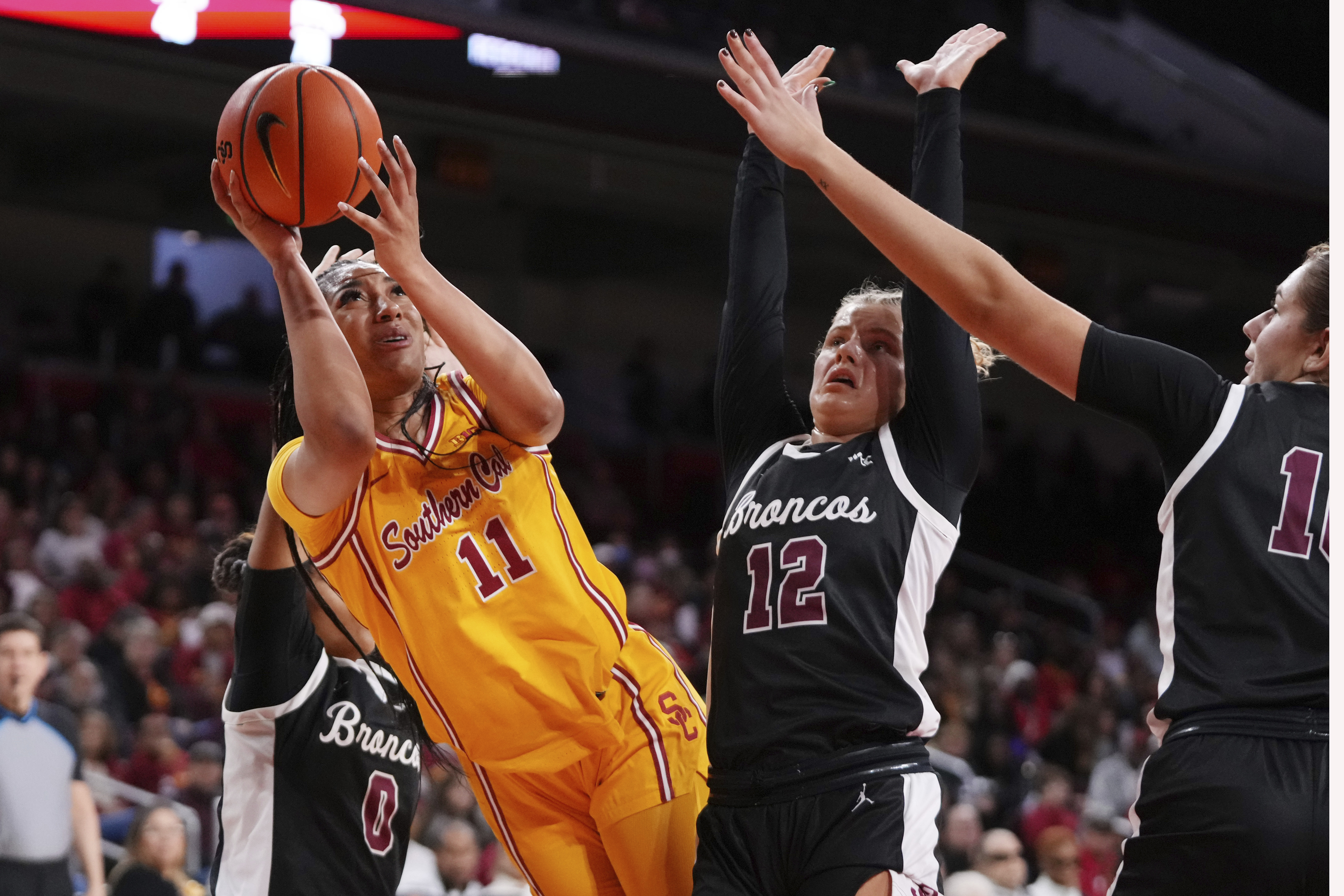 Southern California guard Kennedy Smith (11) shoots as Santa Clara guard Malia Latu (0), guard Maddie Naro (12) and forward Georgia Grigoropoulou defend during the second half of an NCAA college basketball game, Friday, Nov. 15, 2024, in Los Angeles. 