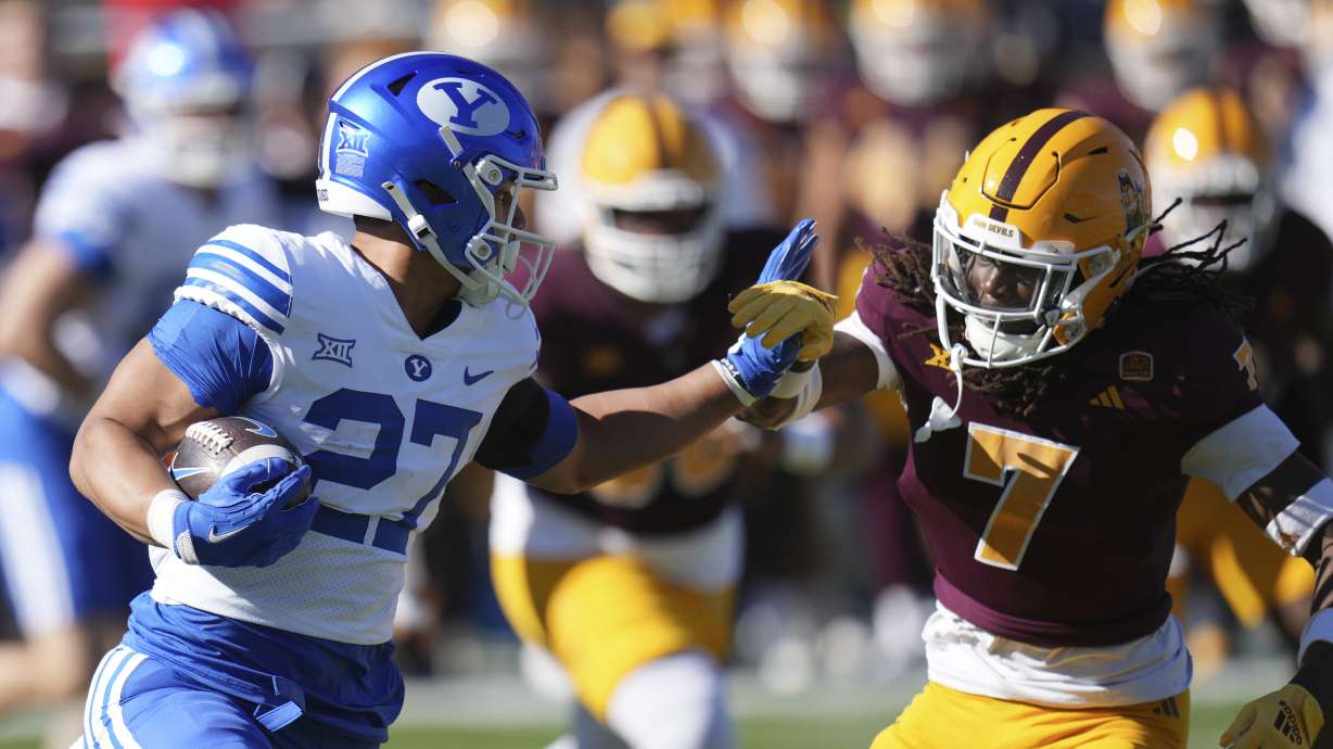 BYU running back LJ Martin (27) tries to get past Arizona State defensive back Shamari Simmons (7) during the first half of an NCAA college football game Saturday, Nov. 23, 2024, in Tempe, Ariz.