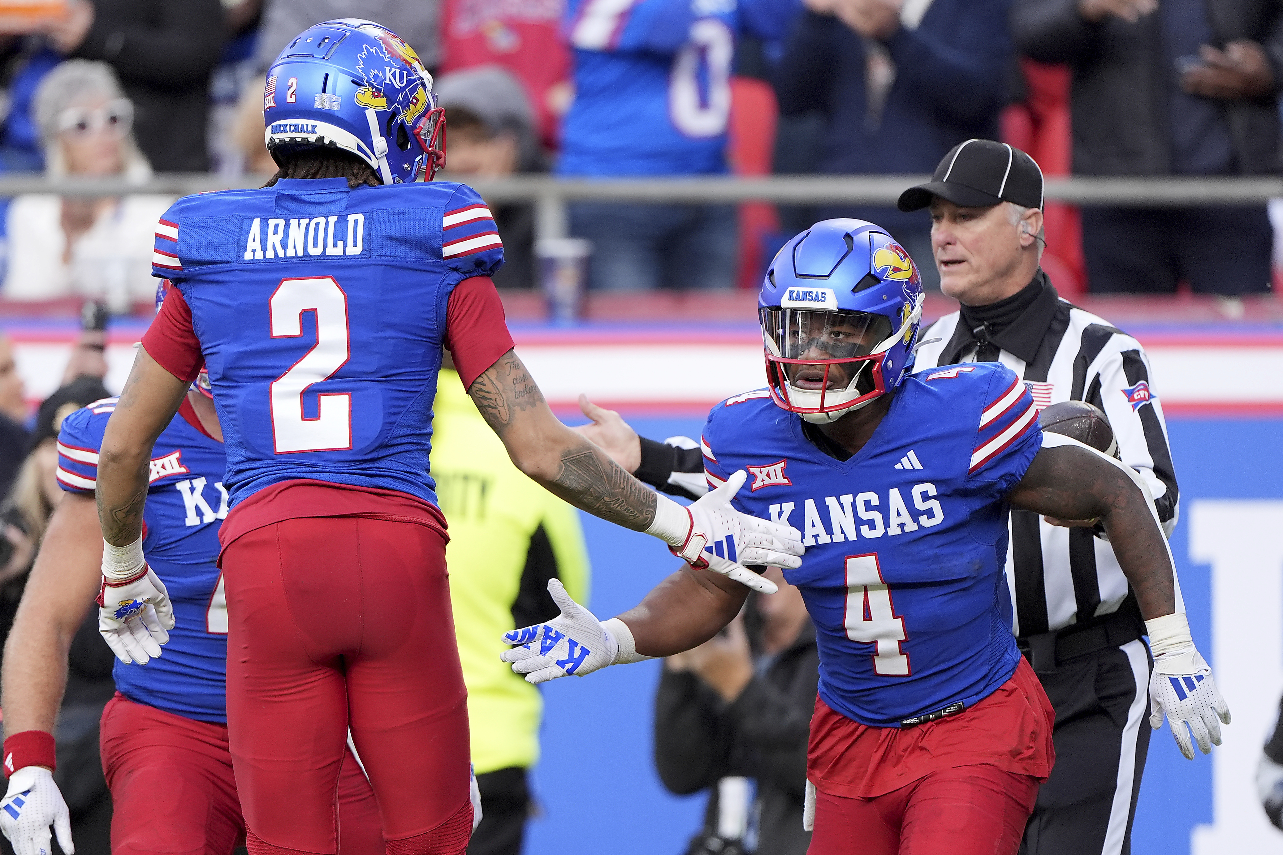 Kansas running back Devin Neal (4) celebrates with Kansas wide receiver Lawrence Arnold (2) after scoring a touchdown during the first half of an NCAA college football game, Saturday, Nov. 23, 2024, in Kansas City, Mo.
