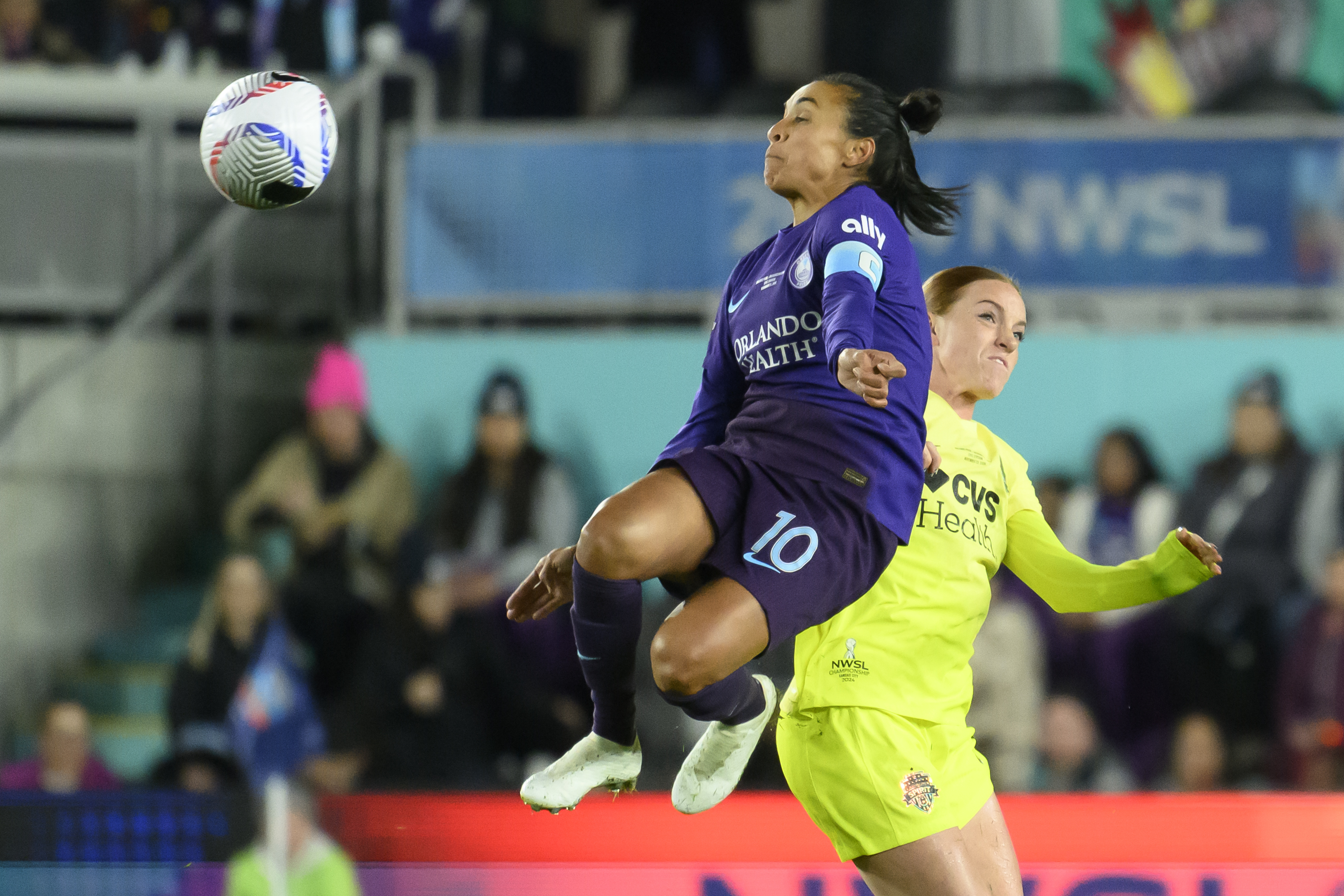 Orlando Pride forward Marta (10) leaps into the air to make a play on a ball in front of Washington Spirit midfielder Hal Hershfelt, right, during the first half of the NWSL championship at CPKC Stadium, Saturday, Nov. 23, 2024, in Kansas City, Mo.