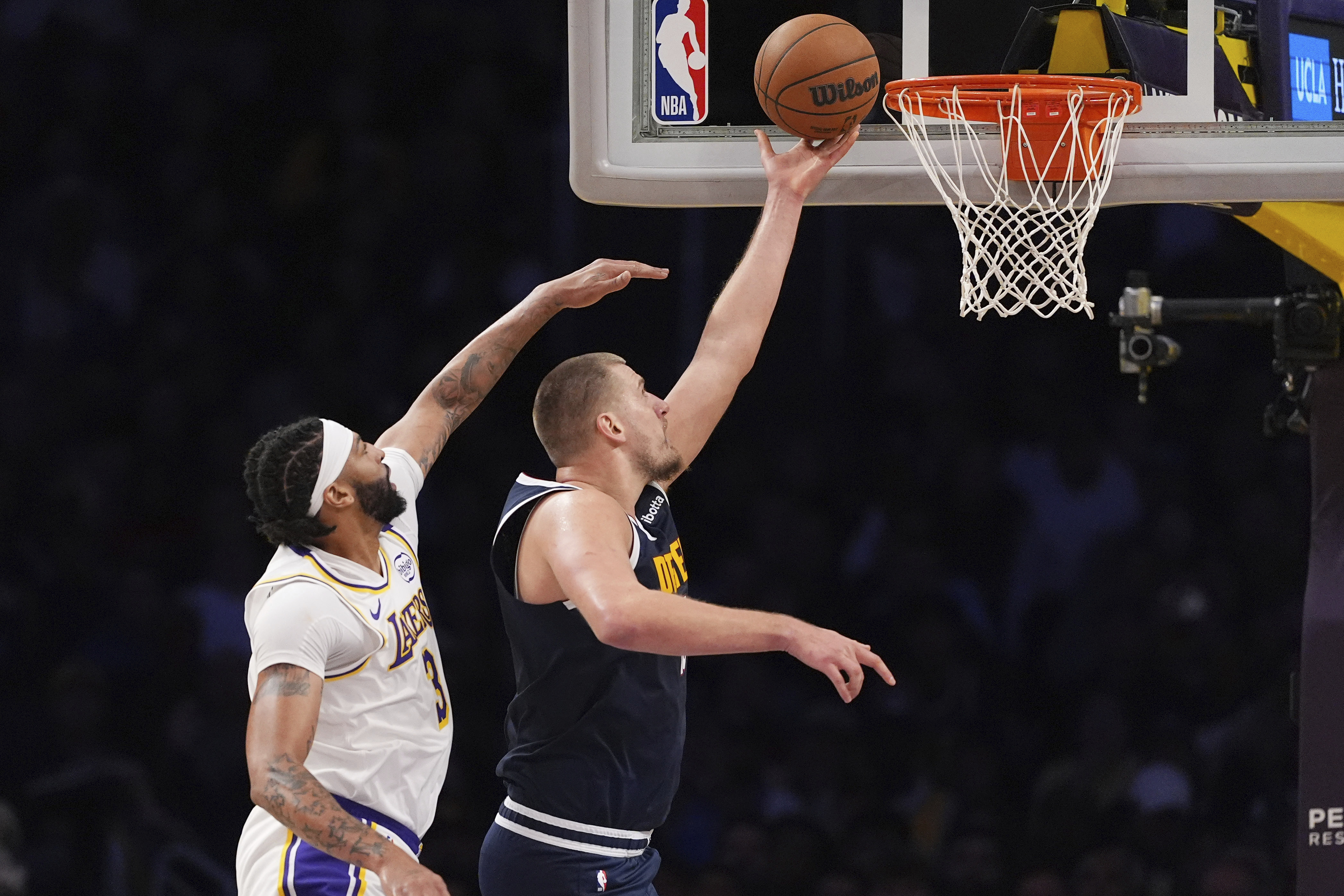 Denver Nuggets center Nikola Jokic, right, shoots as Los Angeles Lakers forward Anthony Davis defends during the first half of an NBA basketball game, Saturday, Nov. 23, 2024, in Los Angeles. 