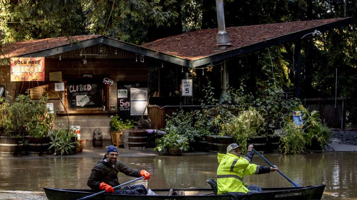 Kevin Ozorkiewicz, left, and neighbor John Phillips row a canoe at the flooded Mirabel RV Park & Campground after a major storm in Forestville, Calif., Sonoma County, Saturday.