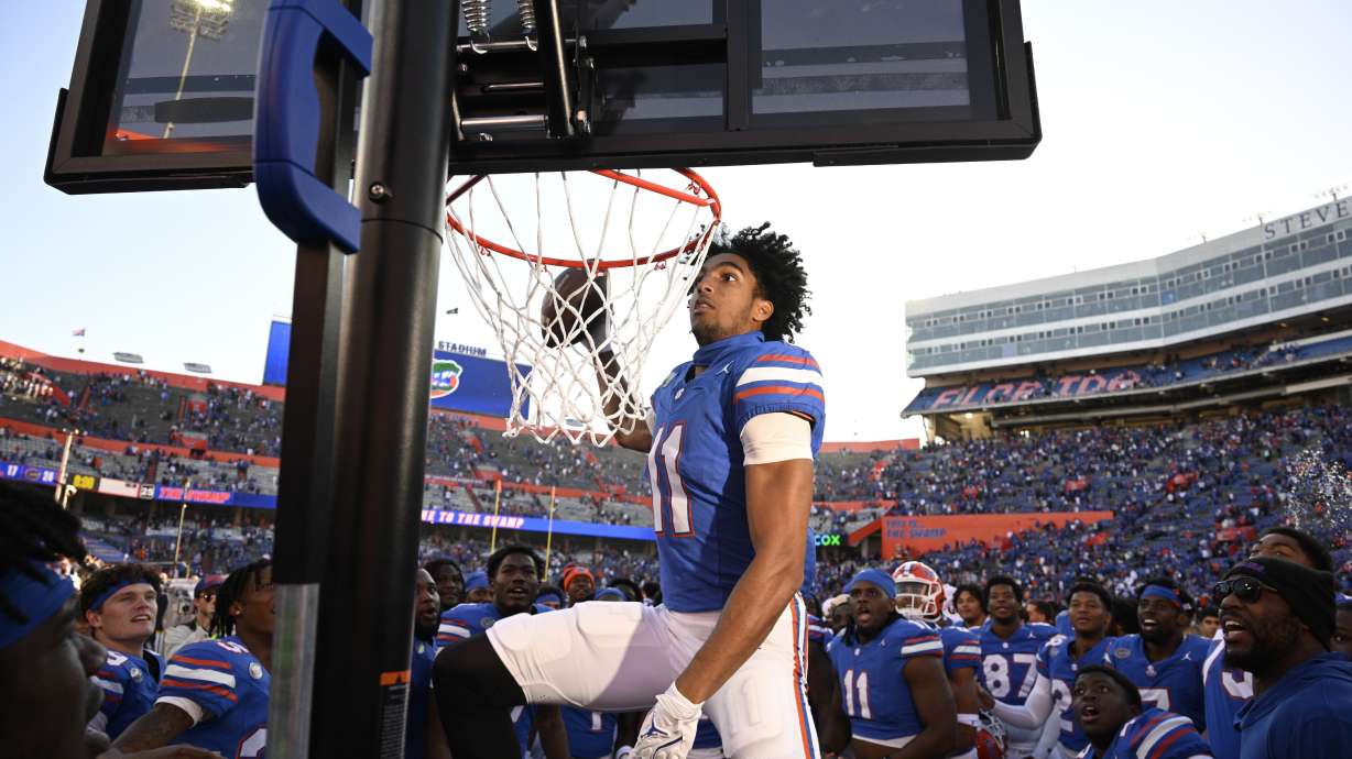 Florida wide receiver Aidan Mizell (11) performs a celebratory dunk using a basketball backboard placed on the Mississippi sideline after their 24-17 win in an NCAA college football game, Saturday, Nov. 23, 2024, in Gainesville, Fla.