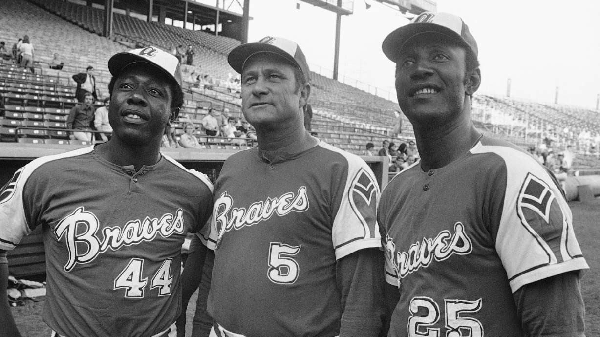 FILE - Atlanta Braves' Rico Carty, right, Hank Aaron, left, and Lew Burdette look up into stands at night on May 22, 1972 before exhibition game against the Brewers in Milwaukee.