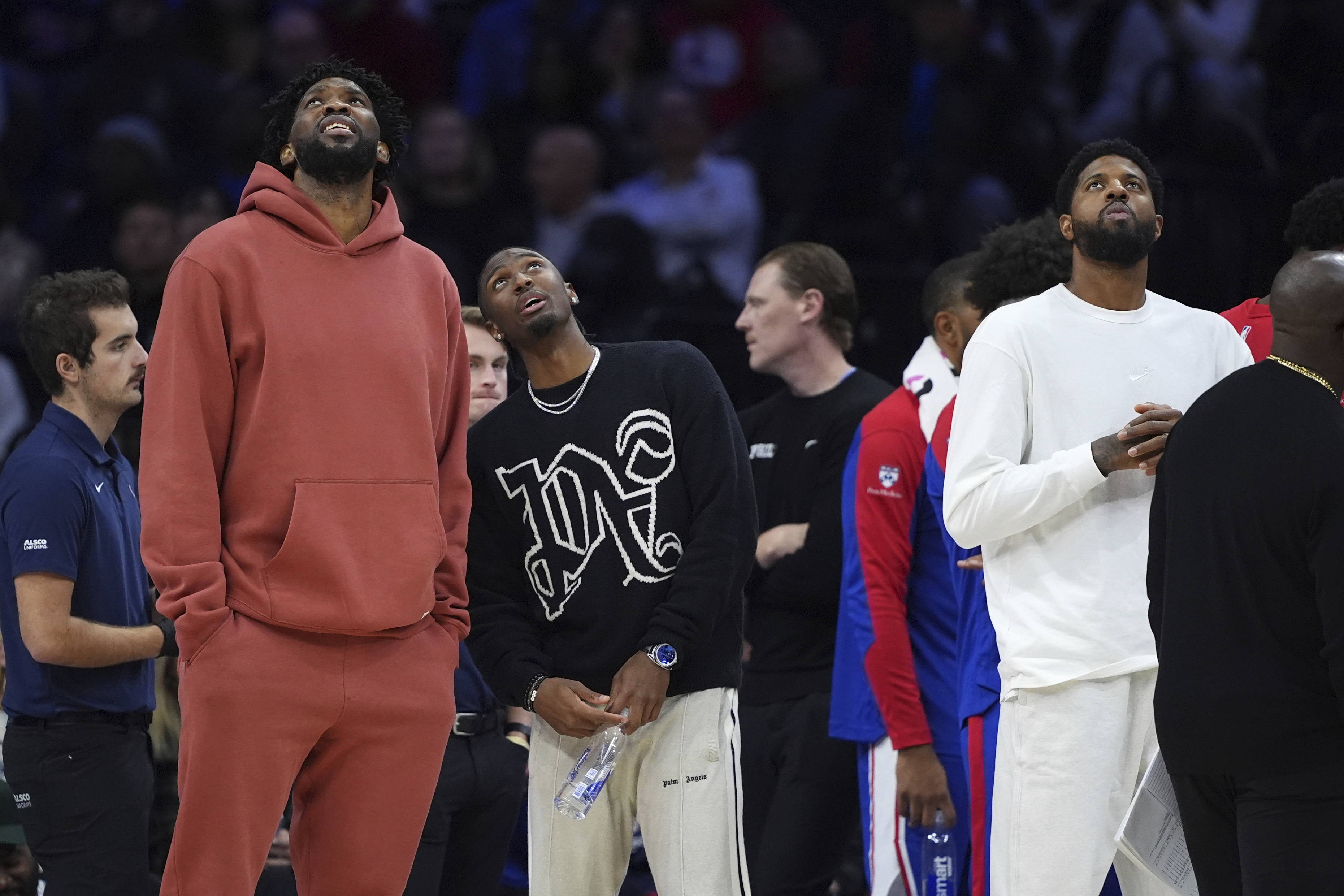 Philadelphia 76ers' Joel Embiid, from left, Tyrese Maxey and Paul George look towards the scoreboard during a timeout during the first half of an NBA basketball game against the Cleveland Cavaliers, Wednesday, Nov. 13, 2024, in Philadelphia. 