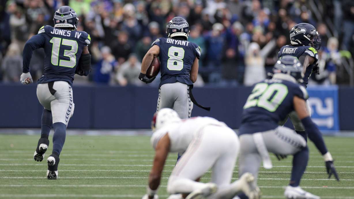 Seattle Seahawks cornerback Coby Bryant (8) runs the ball for a touchdown after making an interception during the second half of an NFL football game against the Arizona Cardinals, Sunday, Nov. 24, 2024, in Seattle.