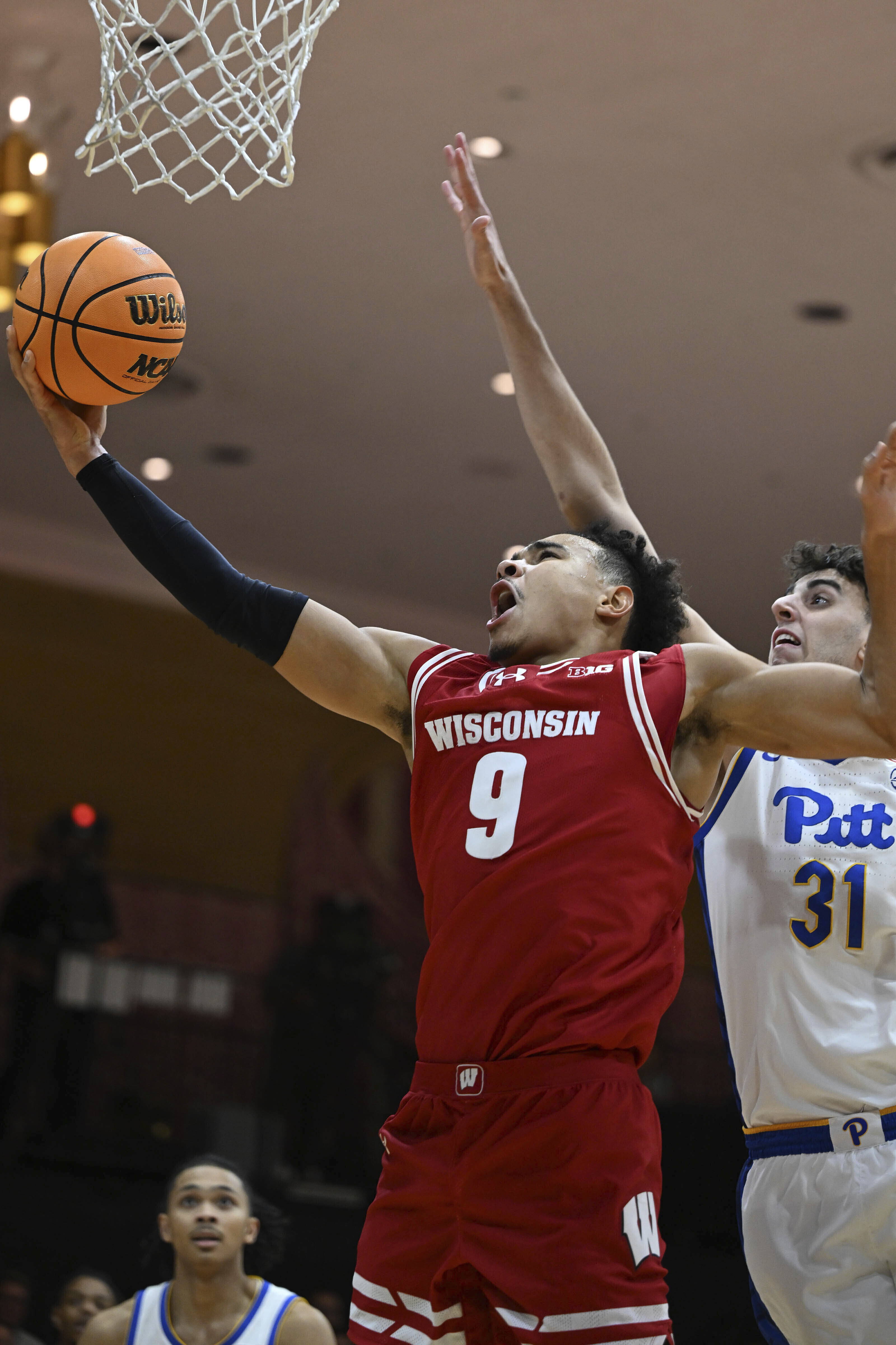 CORRECTS TO FAMILY NAME OF JOHN TONJE - Wisconsin's John Tonje (9) goes up for a layup as Pittsburgh's Jorge Graham tries to block his shot in the first half of an NCAA college basketball game on Sunday Nov. 24, 2024, in White Sulphur Springs, W.Va.