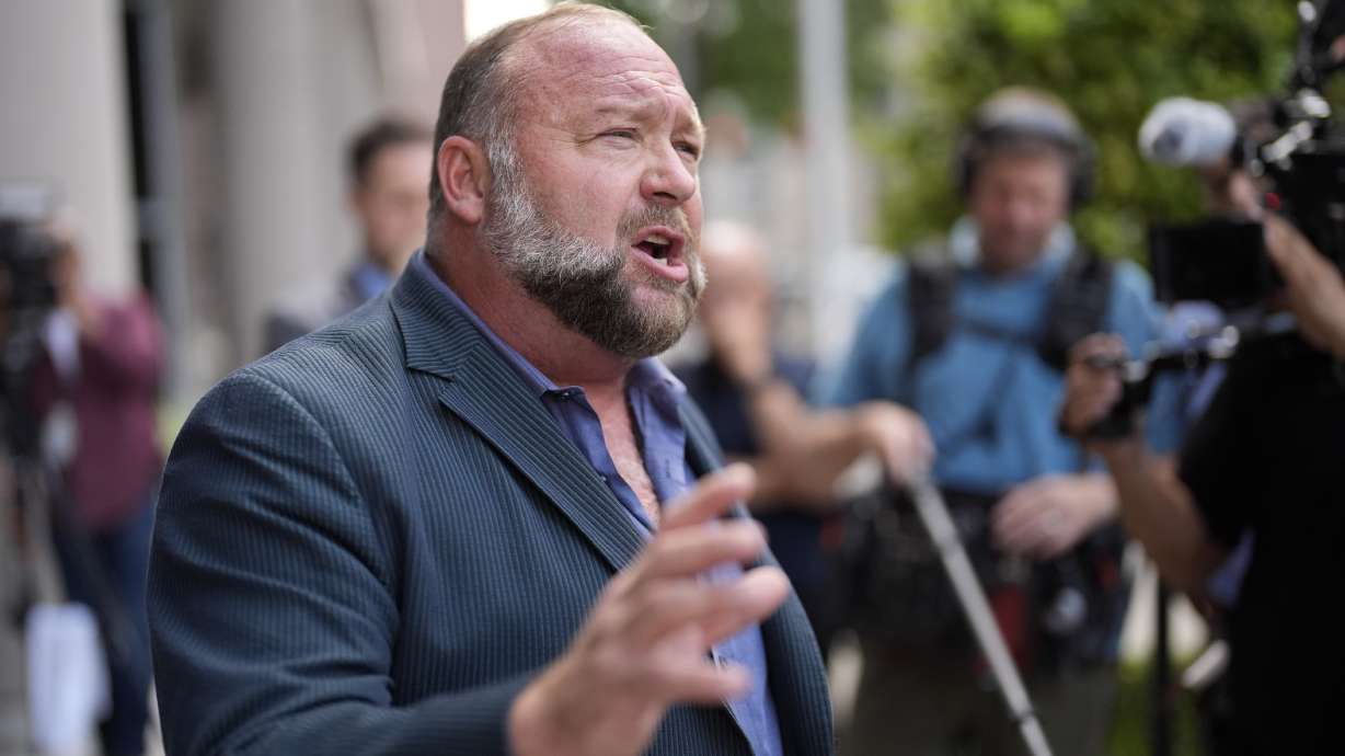 Alex Jones speaks to the media after arriving at the federal courthouse for a hearing on June 14. He is scheduled to appear in court to stop The Onion from buying his conspiracy-theory-promoting site, InfoWars.
