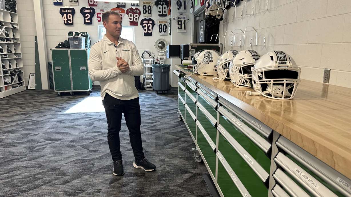 Andrew Kolpacki, Michigan State University's head football equipment manager, surveys players' helmets located on a table inside the school's football complex, Monday, Nov. 18, 2024, in East Lansing, Mich.