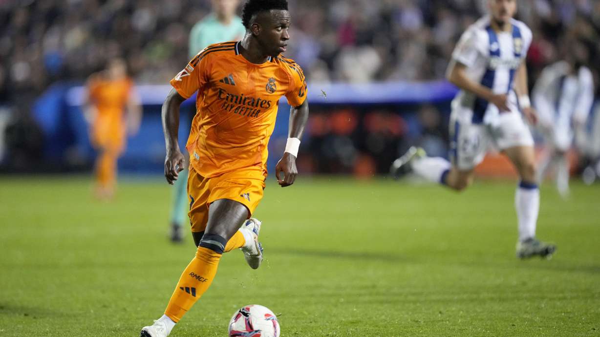 Real Madrid's Vinicius Junior runs with the ball during a Spanish La Liga soccer match between CD Leganes and Real Madrid in Leganes, outside Madrid, Sunday, Nov. 24, 2024.