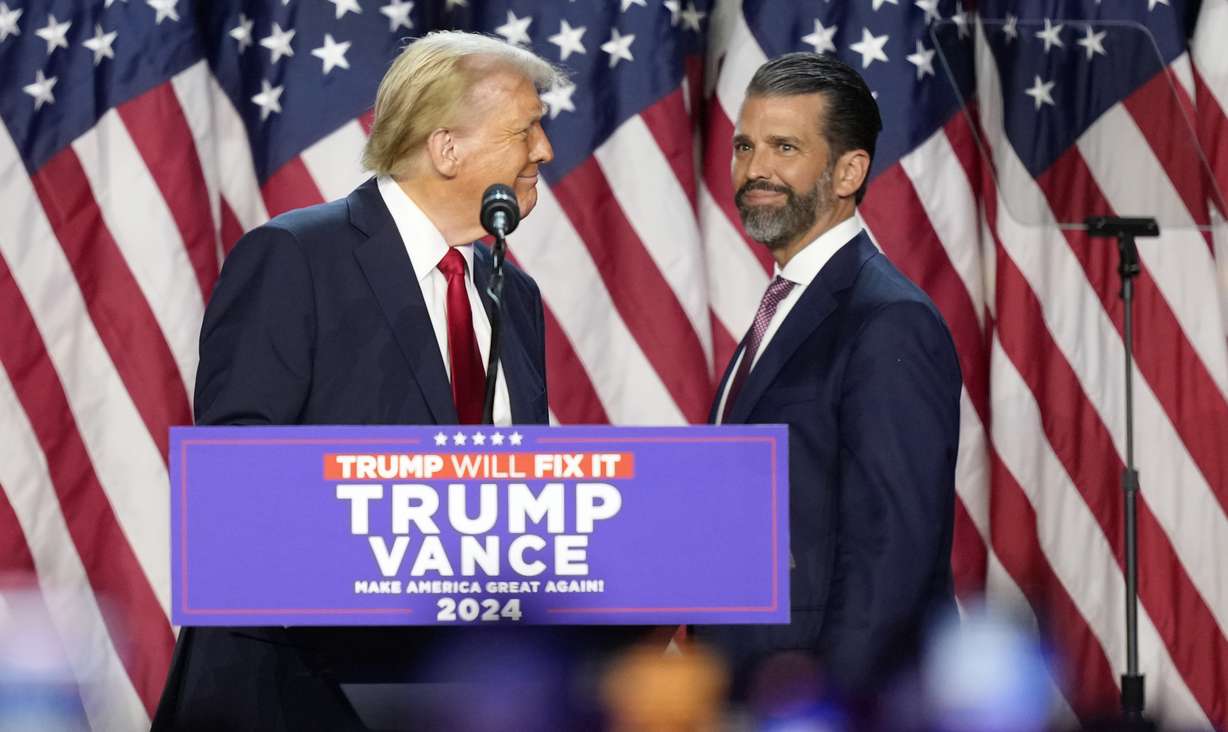 Republican presidential nominee former President Donald Trump, left, looks at his son Donald Trump Jr. at an election night watch party, Nov. 6, 2024, in West Palm Beach, Florida.