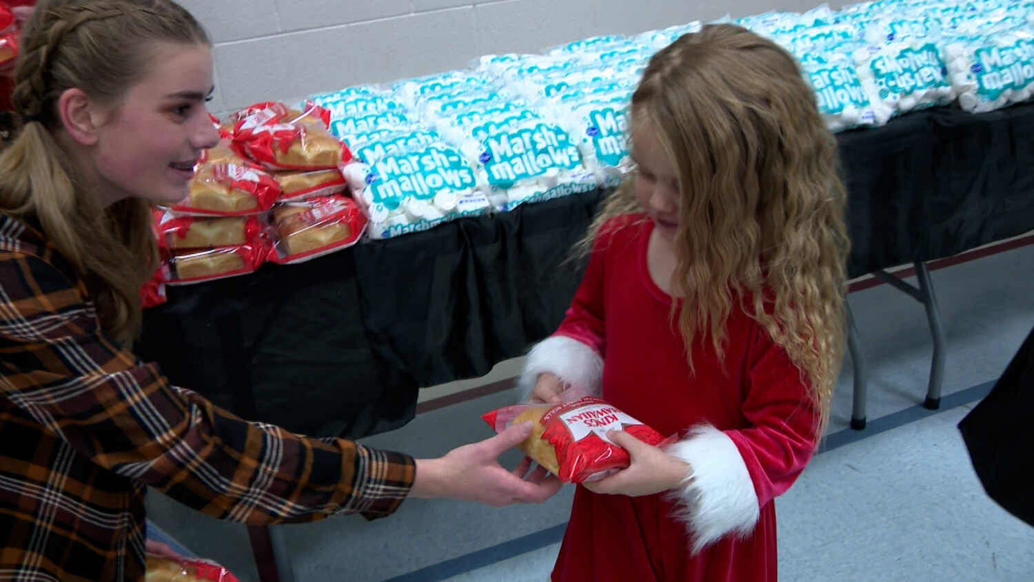 A girl receiving a package of bread rolls at a Thanksgiving food event in West Jordan Sunday.