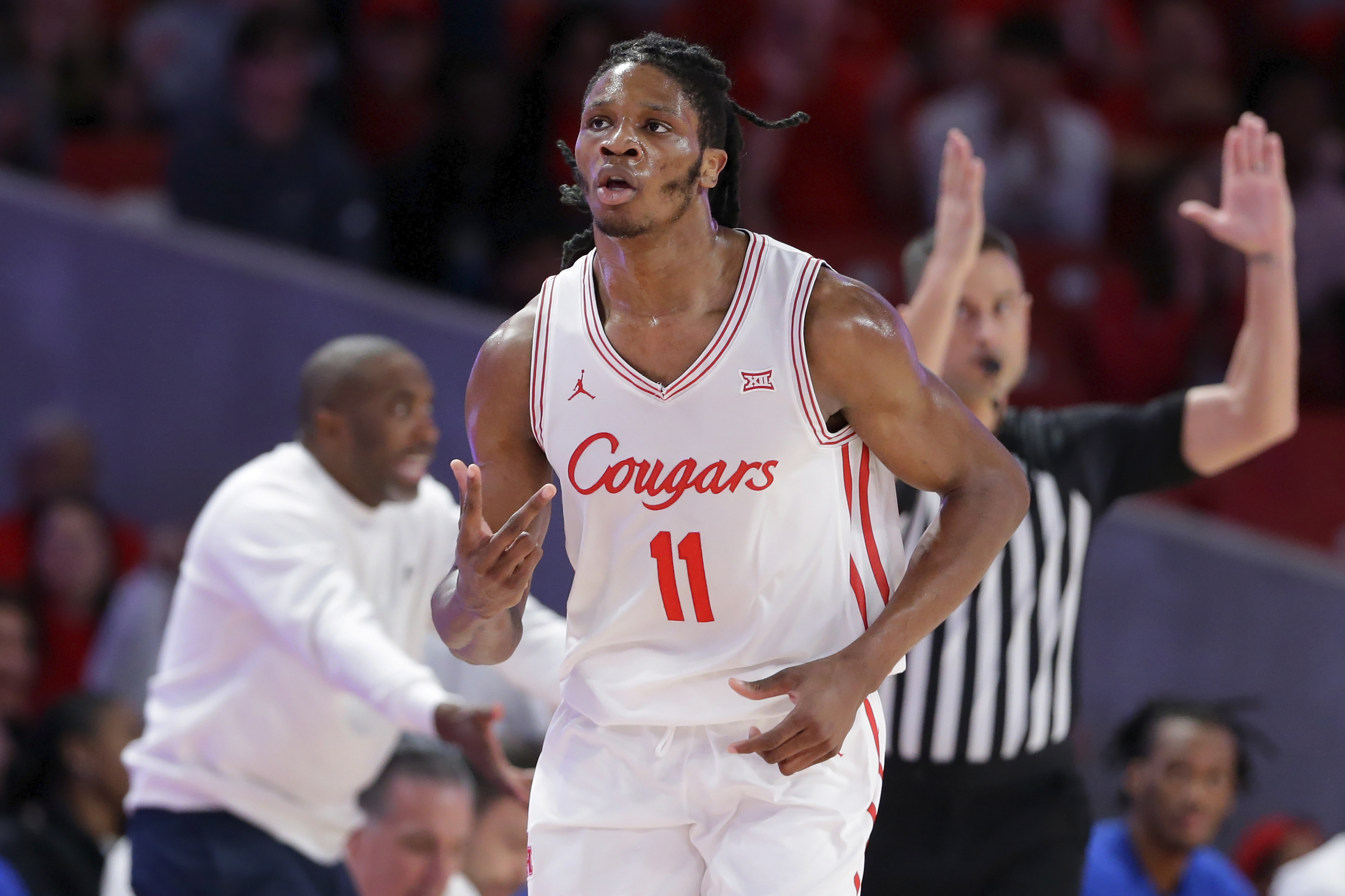 Houston forward Joseph Tugler (11) reacts after sinking a 3-point basket against Hofstra during the first half of an NCAA college basketball game Friday, Nov. 22, 2024, in Houston. 