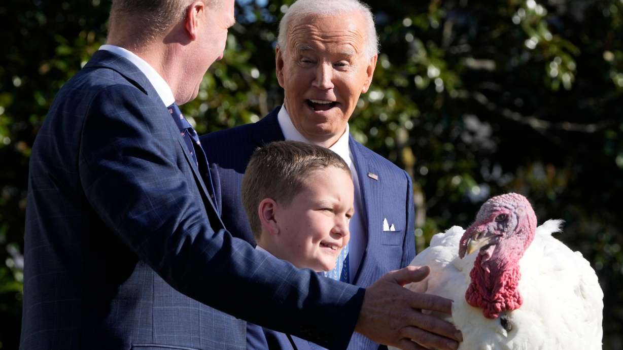 President Joe Biden with John Zimmerman, of the National Turkey Federation, from left, and Zimmerman's son Grant, after pardoning the national Thanksgiving turkey Peach during a ceremony at the White House in Washington, Monday.