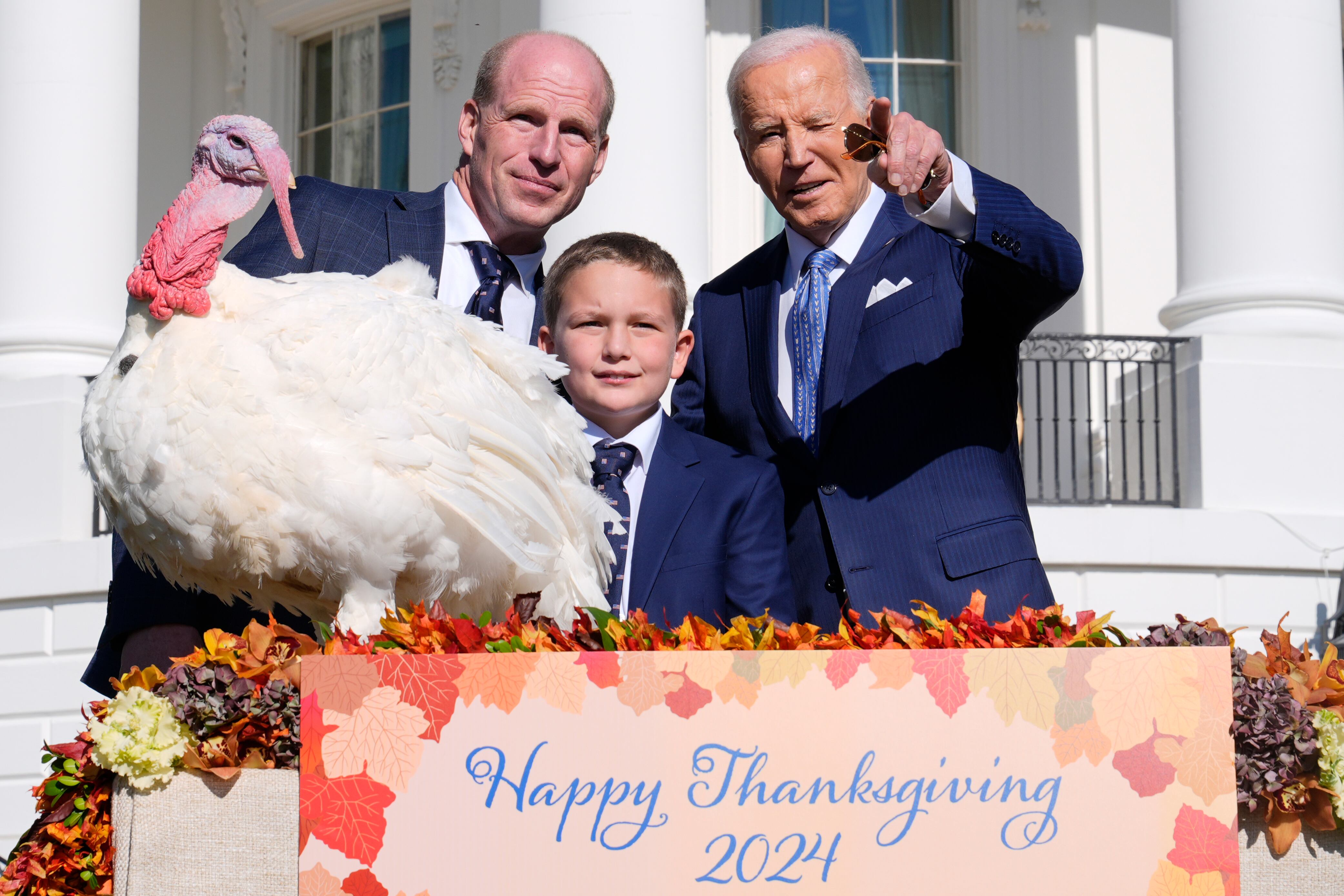 President Joe Biden, right, stands with John Zimmerman, left, chairman of the National Turkey Federation, his son Grant Zimmerman, center, and the national Thanksgiving turkey, Peach, during a pardoning ceremony on the South Lawn of the White House in Washington, Monday.